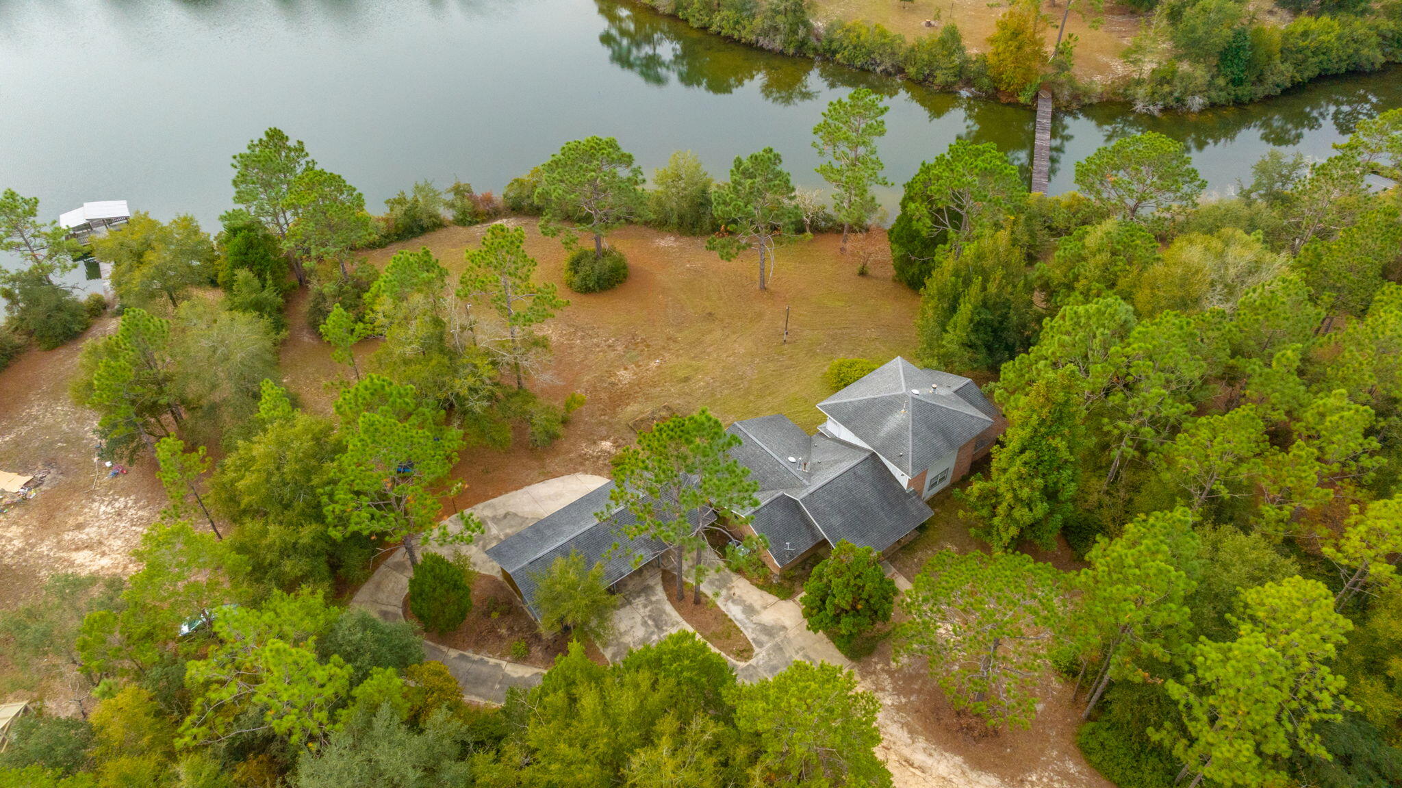 Stunning lake front estate. This 4 bedroom home has it all, the stunning views, expansive land, generous interior rooms, and quiet surroundings. As you walk in the property, you will notice the vaulted ceilings, wood flooring and open concept living space. The kitchen is spacious with breakfast bar, cabinets galore, and a HUGE pantry/laundry room area. Master bedroom is on the first floor with an additional bedroom and full bathroom. The upstairs features two bedrooms and a full bath. Additional family room, covered carport, and porch for your enjoyment!