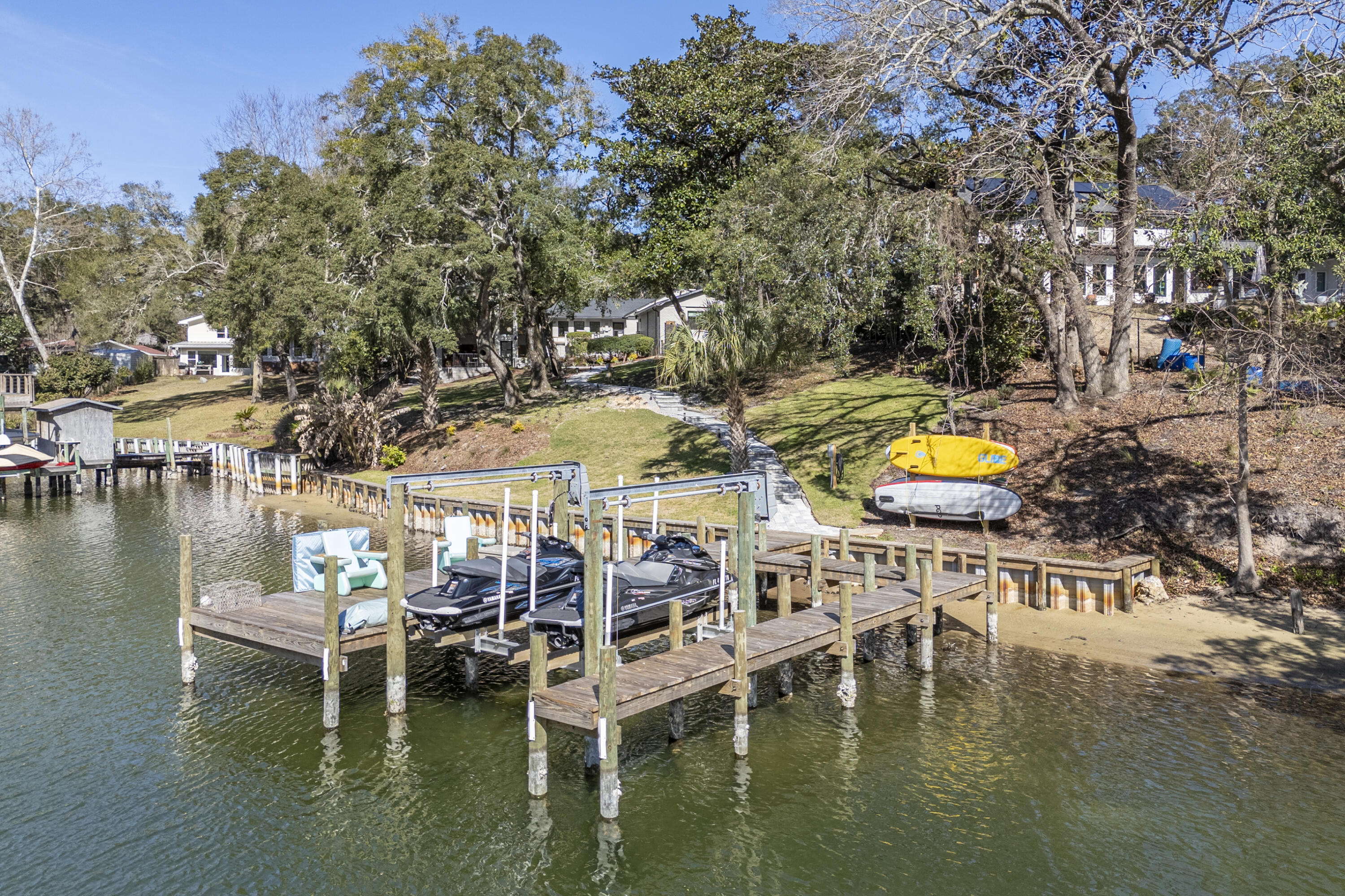 Welcome to this stunning waterfront oasis, fully remodeled down to the studs with exceptional attention to detail. The Property Appraiser has updated the Effective Year Built Date to 2020.  This exquisite home features 4 bedrooms, 4 bathrooms and a dedicated office, offering both luxury and functionality.  Thoughtfully curated interiors showcase breathtaking water views from nearly every room.  The custom kitchen is a true showpiece, featuring a four-foot cooktop, quartz countertops, white oak cabinetry and premium finishes throughout.  White oak flooring, honed marble accents and custom lighting elevate the home's sophisticated design.  Major upgrades include a brand-new HVAC system, new roof, updated electrical and plumbing - providing peace of mind along with timeless style.  The property sits on a fully irrigated, nearly one-acre lot featuring new sod, jasmine planted throughout and mature plants and trees covering most of the entire acreage.  A private well supports the irrigation system, creating a lush, serene outdoor retreat that perfectly complements the home's waterfront setting. The driveway is done entirely in paver bricks, as well as the back courtyard and path down to the new dock where there is 150 feet of deep water protected bayou.  This is a rare opportunity to own a beautifully reimagined property where luxury meets natural beauty and unparalleled views.