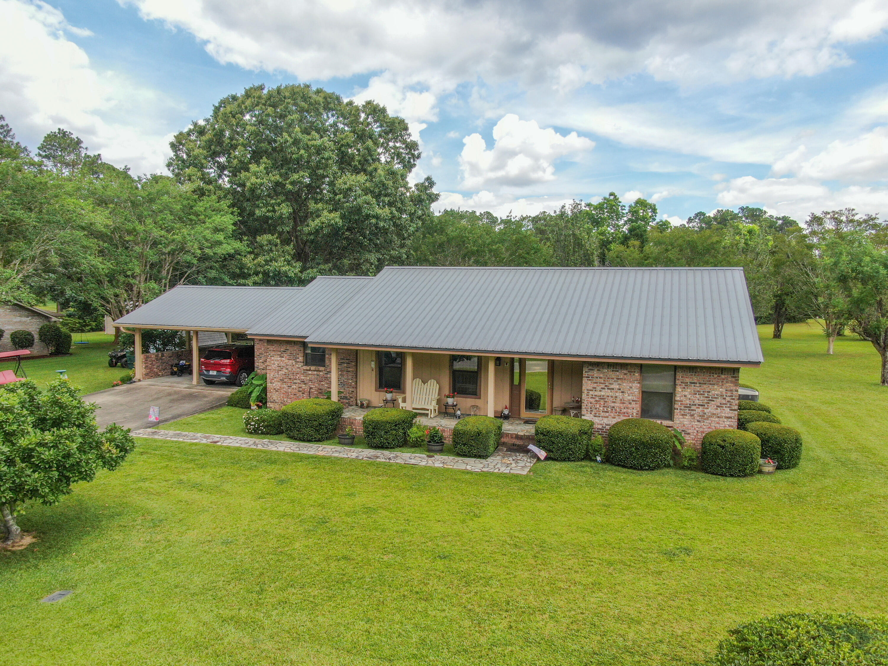 Well maintained Pine Shores brick 3 bed/2 full bath home has loads of curb appeal with a yard your friends and neighbors will envy. Well designed spaces with most square footage where it counts: living room, kitchen/dining, master bed and even the utility room! Real wood shiplap walls in the living room add to the homey feel. The eat-in kitchen with all wood cabinets is rounded out with a special custom coffee bar. Master suite leads to the 30' long screened  porch, with equal sized open patio. The mudroom/utility is a spacious 21x7, perfect for dropping your shoes and bags at the carport door in route to the kitchen. Striking mature maple & crepe myrtles adorn the yard, along with mouth watering satsumas. All on 2/3 acre in the locals' favorite neighborhood of Pine Shores. Welcome Home!