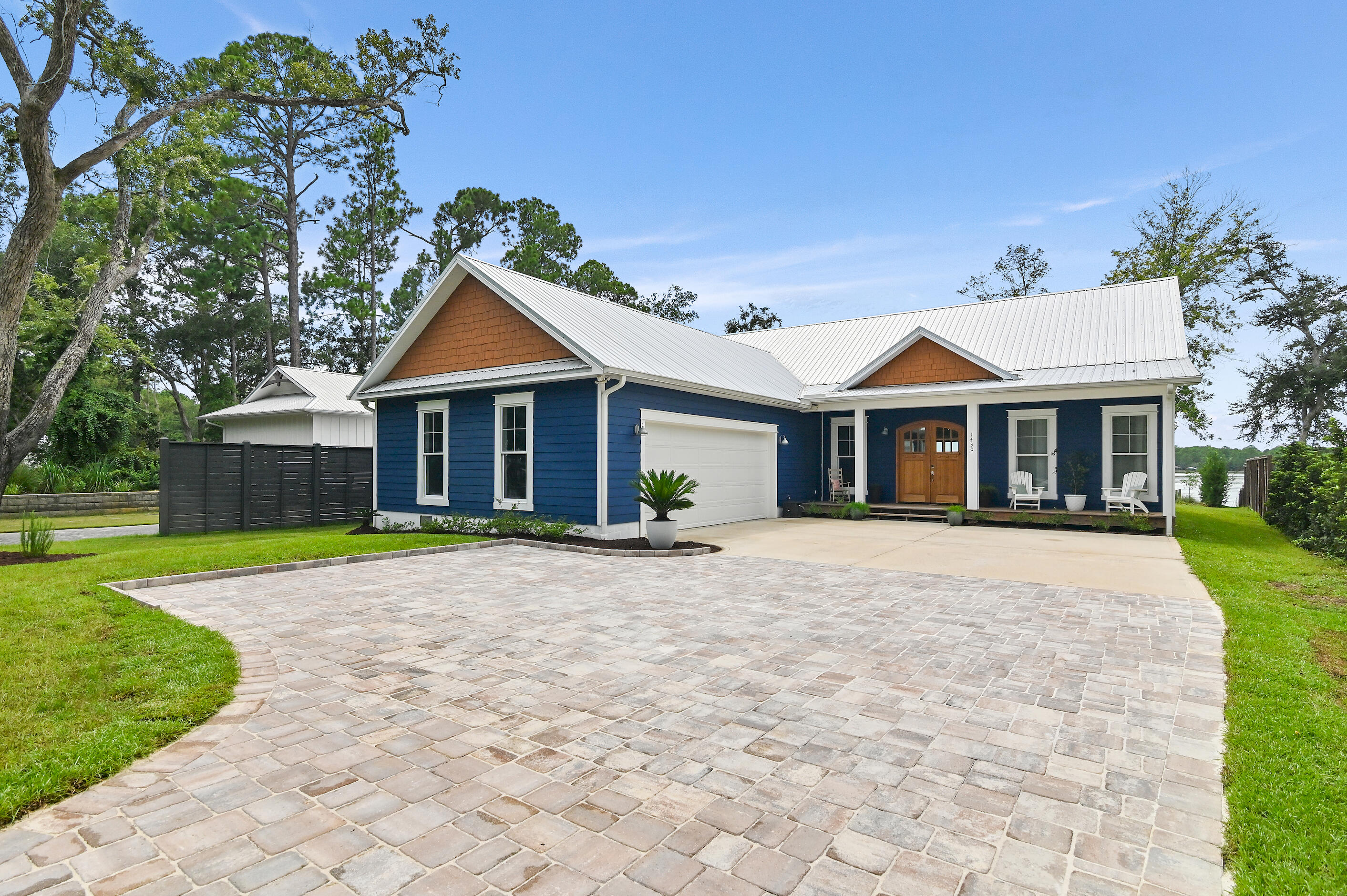 Indulge in the pinnacle of bayfront luxury with this exceptional custom-built waterfront estate on over half acre designed with room for a pool, nestled along the serene Lagrange Bayou perfectly juxtaposed to offer one of the only true westerly sunset views on the bayou, yet tucked back just enough to avoid high north/south wind gusts off the bay making for peaceful and pleasant outdoor experiences. AMAZING LOCATION, LOCATION, LOCATION just 3 minutes to shopping or the 331 bridge from Lagrange Rd., less than 10 minutes to the Hwy 98 to traverse anywhere east or west in the panhandle, and finally just 15 minutes from the world-renowned sugar-white sand beaches along 30A and the emerald waters of the Gulf of America, world-class golf courses, unrivaled fresh seafood and exquisite coastal cuisine. The private dock makes boating to North Beach Social and The Bay restaurant effortless, both just a scenic 10-15-minute boat ride away. 

It's truly the best of all worlds where you enjoy the small town charm of a friendly bay community with NO HOA that is SO CONVENIENT to everything you need in-town just around the corner from boutique shopping and the constantly growing commercial retail such as Publix just minutes away and the new Wal-Mart being developed. You are less than 40 minutes to the International airport (ECP) in Bay County, FL and 45 minutes to VPS Niceville airport that also provides additional travel times and destinations. Boat rides 15 minutes cruise to dining at The Bay and North Beach Social. 35 minutes East or West to fishing in the Gulf.

Masterfully built and thoughtfully designed, this residence was constructed in 2022 and combines elegant coastal architecture with modern functionality, offering approximately 104 feet of private shoreline (partly beach shoreline), a 30-foot boat lift, and deep water access  perfect for yachting, paddleboarding, or tranquil sunset cruises. 

From the moment you arrive, a newly installed paver driveway sets the tone with elevated curb appeal, guiding you toward a home that radiates warmth, sophistication, and understated opulence. Inside, the residence features rich hardwood flooring throughout, soaring ceilings, and a chef's kitchen adorned with premium stainless steel appliances, lavish granite countertops, custom backsplashes, and bespoke cabinetry. The primary suite offers a walk-in closet that connects directly to a custom-designed laundry room, complete with ample cabinetry, a utility sink, and striking brick-style flooring that adds character and charm.

Designed for both relaxation and entertaining, the west-facing backyard captures stunning sunset views and boasts a spacious covered deck with a fully equipped, custom-tiled summer kitchen. Outfitted with a built-in gas grill, cooktop, and sink, this space invites unforgettable evenings with friends and family along the water's edge. 

With the added assurance of being located in a flood zone AE-8 and zone X as confirmed by a recent flood certification survey (so flood insurance is not required and nominal in cost should you choose to purchase), this one-of-a-kind home is not only beautiful but built for peace of mind. Whether you're searching for a luxurious primary residence or a turn-key second home convenient to 30A and literally everything you need, this Lagrange Bayou masterpiece offers a lifestyle defined by elegance, ease, and unparalleled waterfront living.