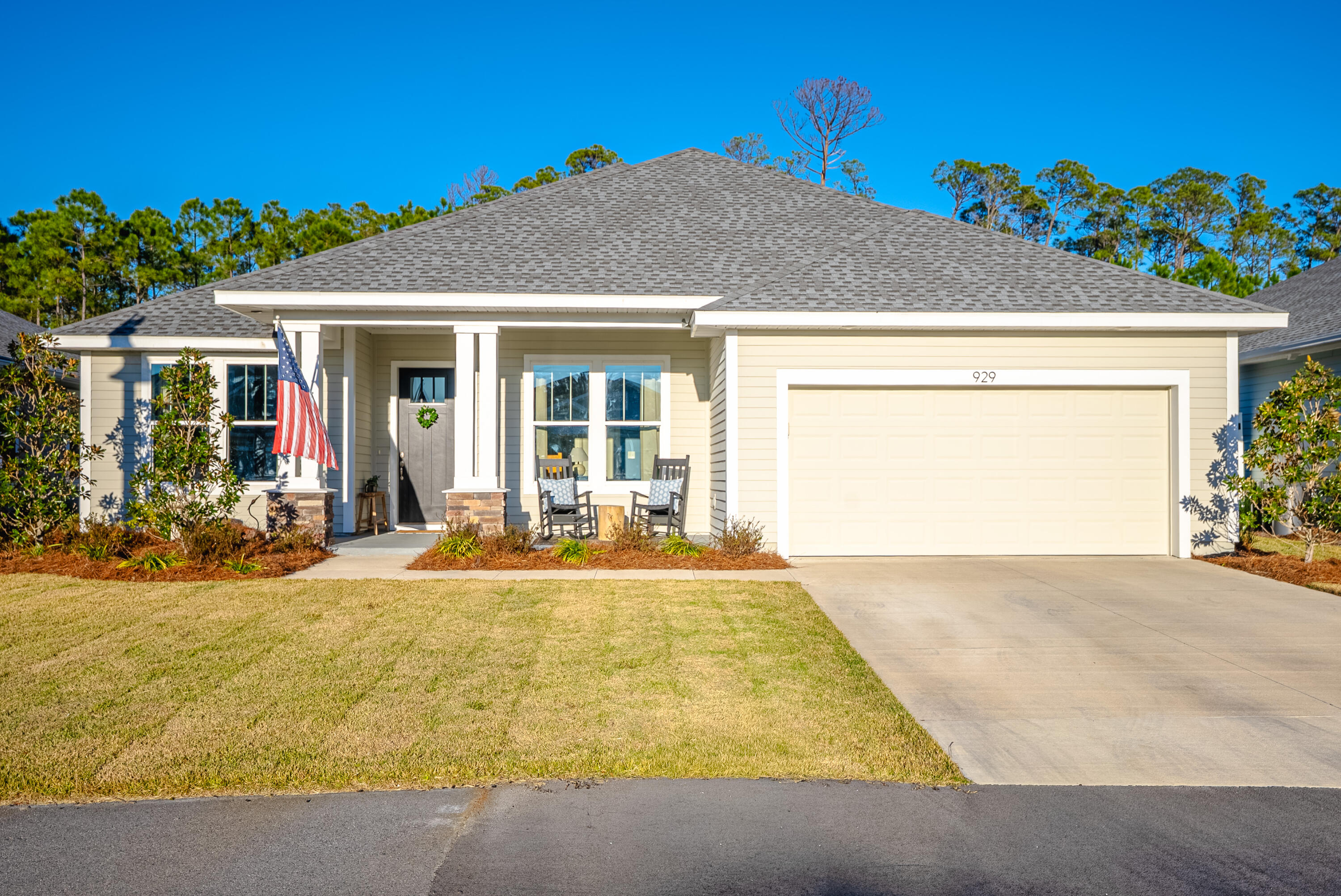 Welcome to the pinnacle of luxury coastal living in Breakfast Point East. This exceptional Tripletail II with the Coastal Cottage elevation offers approximately 3,101 square feet of thoughtfully designed living space, featuring four bedrooms, three and a half baths, and a spacious bonus room that can easily function as a fifth bedroom or flexible living space to suit your needs.The Owner's retreat (Master's suite), two bedroom and bonus room all on first floor!  Built with safety, durability, and efficiency in mind, this home is one of the rare properties in Breakfast Point constructed with 2'' x 6'' steel framing, a hurricane tie-down rod and anchor system exceeding Category 5 wind resistance, and spray-foam insulation for superior comfort and energy efficiency. Situated on a premium lot backing to serene conservation, the home offers privacy and tranquil views. The expansive backyard is pool-ready, with electrical already in place, providing the perfect opportunity to create your own private tropical retreat. Due to superior construction this house has low insurance costs under $1500 for present owners and power bills are low too!Inside, the home showcases 9- and 10-foot ceilings, large-format tile in the bathrooms, and luxury vinyl plank flooring throughout the main living areas. The kitchen and living spaces feature a cohesive, upgraded finish package with a light, coastal-inspired aesthetic. The kitchen is anchored by full-height shaker-style cabinetry in a soft off-white finish, accented with brushed nickel hardware and crown molding extending to the ceiling. Quartz countertops with subtle gray veining provide a refined and durable surface, including the oversized center island that offers generous prep space and casual seating. A vertically stacked elongated tile backsplash with a gloss finish extends behind the range and stainless vent hood, creating a striking focal point. The appliance package includes a counter-depth refrigerator, built-in microwave, stainless gas range, undermount sink, and a high-arc pull-down faucet, completing the space with both function and style.
Wide-plank flooring in a light natural wood tone flows seamlessly through the kitchen and main living areas, enhancing the open and airy feel. Recessed LED lighting and decorative clear-glass pendant fixtures provide balanced task and ambient lighting, while neutral wall tones, taller baseboards, and craftsman-style trim reinforce the home's timeless appeal.
The entry and staircase further reflect the home's upgraded character, featuring natural wood stair treads, white painted risers, and a stained handrail that complement the flooring. Square newel posts and painted balusters create a refined transition between levels, while the elevated foyer ceilings enhance the sense of space. The open-concept layout allows for effortless flow between the kitchen, dining, and living areas, resulting in a cohesive, move-in-ready home with strong market appeal and high-end coastal charm.