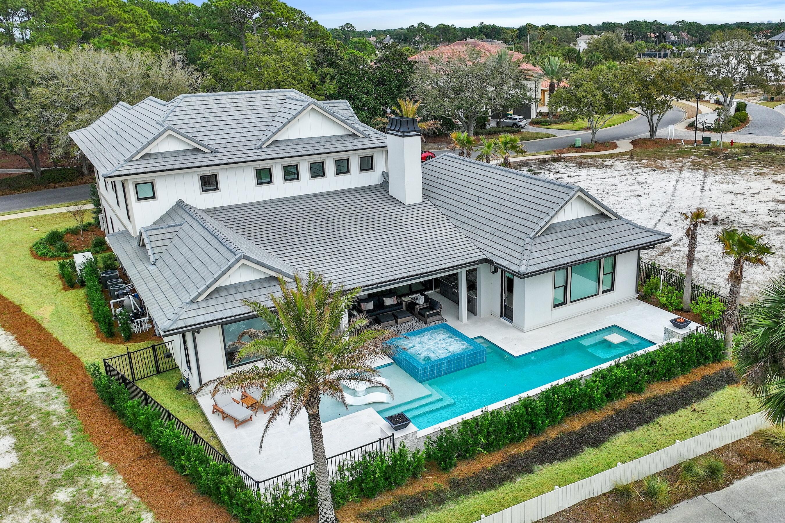 Less than a mile from the beach! Welcome to Tradewinds, the newest community in Regatta Bay consisting of 54 homesites with a West Indies/Dutch architectural influence. This beautiful home was built in 2023 and offers modern luxury indoor/outdoor living w/ 4797 sq. ft. of heated/cooled space, 4 beds, + study, 4 full baths and 2 half baths. Exterior features include an outdoor living space overlooking the golf course and lake with covered and uncovered space for entertaining and lounging, summer kitchen, pool/jacuzzi and fire pits. This home features lush landscaping that is maintained by the association, paver driveway and a 3-car garage plus golf cart garage. The home was finished with designer chosen selections throughout including shiplap, Venetian Plaster, tumbled travertine & wood flooring, quartzite & marble countertops and solid wood custom cabinetry just to name a few. The 1st floor offers a split floor plan and includes a family room w/gas fireplace, dining area, gourmet kitchen with all the bells and whistles, scullery with additional kitchen appliances, butler's pantry, wet bar, study, powder bath for guests, laundry room and a guest suite with private bath. The master suite is also located on the 1st floor and features a custom cathedral ceiling with painted wood beams, sitting area and a showstopping master bath which includes separate his and her walk-in closets, separate his and her vanities, separate his and her water closets, a large custom marble tile shower, soaking tub and last but not least a master laundry room! The 2nd floor offers a large entertainment space with wet bar, powder bath for guests, 2 guest suites with private baths and a laundry room. Built by Legendary Home Builders utilizing the most current technology for each build using only the finest materials and high-end finishes such as: wind and impact resistant windows, wind and impact rated doors, insulated, wind and impact rated garage doors, foam spray insulation in roof for superior energy efficiency, insulation in all interior walls for energy efficiency and sound proofing, insulation between floors for sound barrier, stucco homes equipped with Enviro-dry liquid waterproofing house wrap, gas lanterns, stainless steel door hinges, custom wood shelving in all closets, Kohler plumbing throughout, all showers have KBRS waterproofing systems specifically designed to maintain integrity & durability, air conditioning zones for maximum efficiency, Rinnai tankless water heaters, custom solid wood cabinets throughout with soft close hinges, smart home technology customizable for homeowner, LED lighting throughout. Regatta Bay is a quiet, gated, golf & boating community that offers a LIFESTYLE unlike no other! The Regatta Bay Lifestyle is about convenience! You can golf cart to so many fun places in minutes, including the Beach! Within Regatta Bay, there is golf, swimming, tennis, pickle ball, park, playground, Regatta Bay Clubhouse, Legendary Marine & Legendary Yacht Club. Regatta Bay offers a private road that takes residents to the Destin Commons, where you'll find an array of popular men's and women's retail stores, a variety of restaurants, Whole Foods, Bass Pro, Lowes, AMC movie theater and Uncle Buck's Bowling! ALL ACCESSIBLE BY GOLF CART.