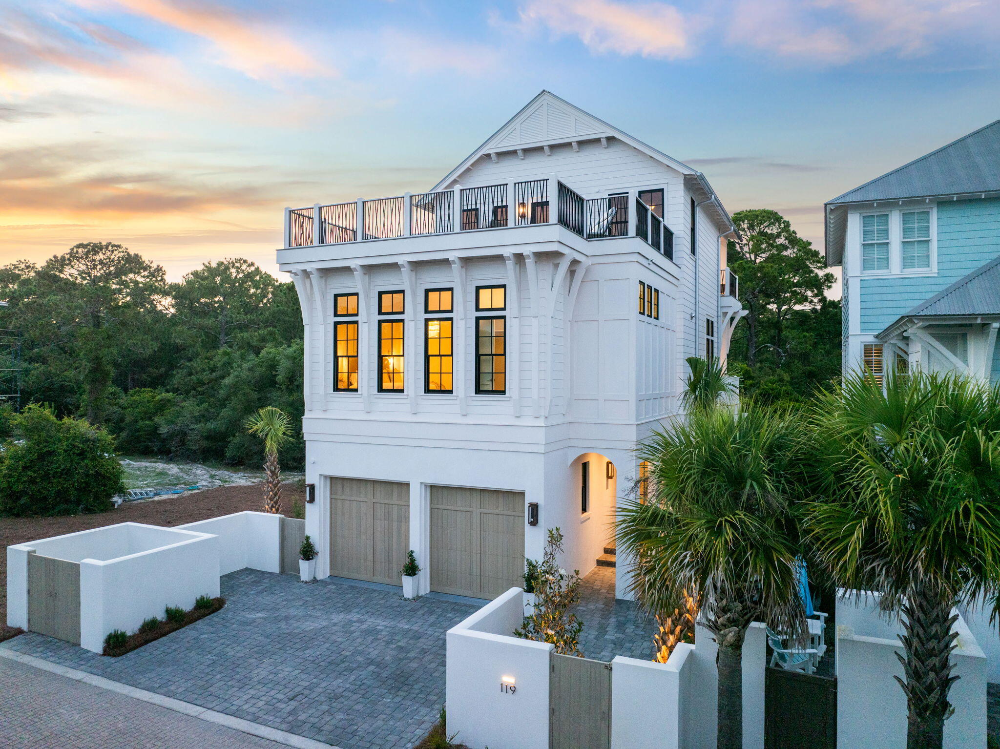 Tucked behind the gates of Seanest Village in Seagrove Beach, this brand-new residence at 119 Sand Oaks Circle is a curated blend of refined coastal architecture and high-end design. With Gulf views from the rooftop deck, forest vistas off the bedrooms, and a walkable location to both Seaside and Greenway Station, this home checks every box for a legacy 30A retreat.
Designed by Gregory Jazayeri and built by the expert team at Focus Construction, the home showcases cypress accent ceilings, 10' coffered details in the main living space, and a vaulted master suite—elevated by a design-forward interior palette thoughtfully curated by Côte Studio. Thermador appliances, custom Italian-style cabinetry, solid core doors, and black Delta fixtures continue the theme of understated luxury throughout. Spread across three levels, the home features four bedroomseach with its own ensuite bathalong with laundry rooms on both the second and third floors. The first floor includes a private guest suite and a full-over-king bunk room, while the second level offers a generous guest suite with a private balcony overlooking the state forest. On the third floor, the primary suite is a peaceful escape with vaulted cypress ceilings, a spa-like bath, walk-in closet, and its own covered terrace among the trees. A full wet bar with beverage cooler, ice maker, and sink opens to the rooftop deckperfect for evening gatherings around the gas fire feature with views of the Gulf.

The craftsmanship extends outdoors with a solid concrete first floor, cement board siding, custom millwork exterior gate, lush landscaping, and low-voltage lighting. A large covered summer kitchen, exterior gas lanterns, and a two-car garage with EV charging complete the offering.

Owners in Seanest Village enjoy deeded beach access, a resort-style community pool, and a central location with convenient access to the very best of 30A. Whether you're entertaining from the rooftop, relaxing on the forest-facing balconies, or strolling to Seaside for dinner, 119 Sand Oaks Circle offers a rare blend of privacy, luxury, and coastal ease.