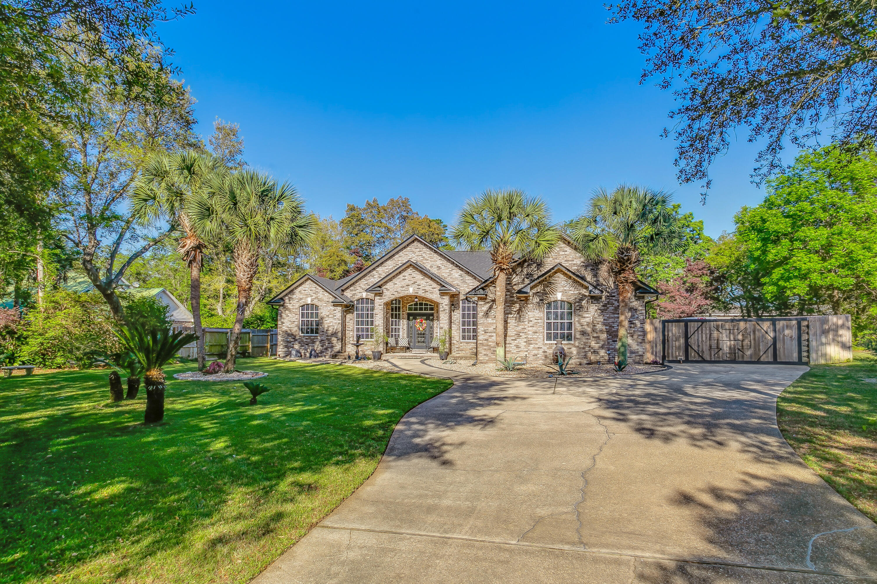 This all brick estate with a brand NEW roof in Holley by the Sea, can be your new forever home. Four bedroom three full bath home with an above ground pool is surrounded by decking and the lush landscape of a .75 acre wood lot. Enjoy a remodeled kitchen and full of tall, 42 inch cabinet storage and white quartz countertops. Any gourmet will appreciate the gas cooktop, matching stainless appliances, and the added benefit of a tankless gas unlimited hot water heater. Generously sized, (3 out of 4) bedrooms can easily accommodate a king-size bed. In the master bedroom, you'll enjoy the French doors, leading out to the backyard and pool deck. The vaulted ceiling gives you the impression of larger scale, and the en-suite renovated bathroom is a luxury retreat, created with for relaxation. The large walk-in shower with zero threshold is framed with popular black and white tile. Adjacent you will enjoy soaking in the classic clawfoot bathtub. Double sink vanity and several closets provide ample storage. Two more full bathrooms on the north side of the house have been tastefully designed and the en suite attached to bedroom 3, has a double entry which leads out to the covered porch close to the pool. 

The heated and cooled glass in porch is surrounded by sliding glass windows on three sides so that it's truly an indoor outdoor space. Ceiling fans throughout the home, provide plenty of air circulation. You'll enjoy the backyard amenities, such as space for outside dining, fire pit, and swimming pool. There's even a iron gated dog run for your pampered pets. The owners extra long circular drive additional paved, parking to the south side of the house, side-entering garage, and an exterior storage building with rollup garage door will provide space for all of your boats, JetSki, trailers and extra vehicle's. Privacy fence surrounds the property and extra large gates allow for easy access to the back. This home is truly an entertainer's paradise and a comfortable Florida retreat.