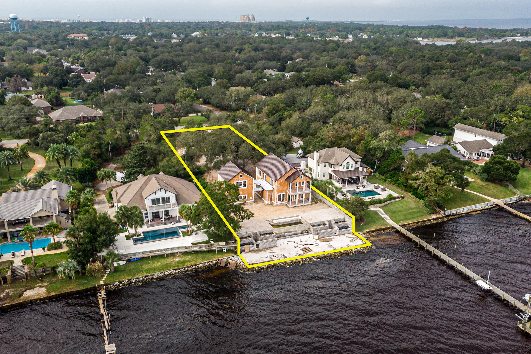 Rare opportunity to acquire one of the most superb waterfront estates in Destin, Florida, 100' of which fronts the scenic Choctawhatchee Bay!  This new construction offers a unique opportunity for a buyer to acquire a project of profound structural integrity, owned by a seller who has the utmost care and concern for quality and craftsmanship.  Perched atop one of the highest elevations in the area, this .88-acre compound is oriented for convenient and private access on the preferred west end of Indian Trail.  Magnificent live oaks grace the site, setting the perfect stage for a stately drive meandering through the indigenous landscape, leading to your new 3,850 SF home and carriage home, as well as your two-car garage, pool, beach, and... coveted bay views!  
     
A covered breezeway attaches the main home with the garage. The carriage home is independently accessible for the privacy of guests. All exterior balconies are decked with beautiful Ipe, a costly wood species that is naturally resistant to rot, as it is nearly twice as dense as other woods and immensely stronger. All the windows are impact resistant, with glass that contains special UV-filtering qualities, and fabulous interior and exterior mahogany doors, all custom-milled and built by renowned EF San Juan.
     
The extra-reinforced foundation sits over 17' above sea level and utilizes fiberglass as opposed to rebar to prevent corrosive fracturing, as well as to achieve superior strength. Through the building process, following the installation of the standing seam metal roof, the interior of both the main home and carriage home have been climate-controlled by temporary air-conditioning units, further supporting a more pure indoor air environment. All wiring throughout the home is typical of a commercial-grade installation, encapsulated by flexible metal conduit. All ductwork is fabricated from sheet metal to circulate more pure air than with fiberglass ductwork. The drywall finish throughout is silky-smooth, all accomplished under "Level 5" finish specifications.
      
The spectacular infinity edge pool and its waterfall will cascade to a basin far beneath, serving as a stunning backdrop to the white-sandy beach, three sides of which are surrounded by the beautiful bay water. Integrated with formed concrete and CMU block to reinforce and protect the highly elevated homesite, the terrace structure leads to the rare sandy beach that extends much beyond the neighboring shoreline. The beach is surrounded by vinyl sheet piling and rip-rap, all of which reflects over $250,000.00+ of existing site improvements. Considering the extraordinary current cost of lumber, this existing project reflects a value for a discerning Buyer to assume it from its current state, completing the finishes of preference, which will result in a magnificent compound and newly completed home that would command a significant pricepoint following completion.
      
Please inquire for further details and to schedule a private showing, as scheduled appointments are required to access the property and improvements thereon. Plans and surveys are uploaded to this listing.