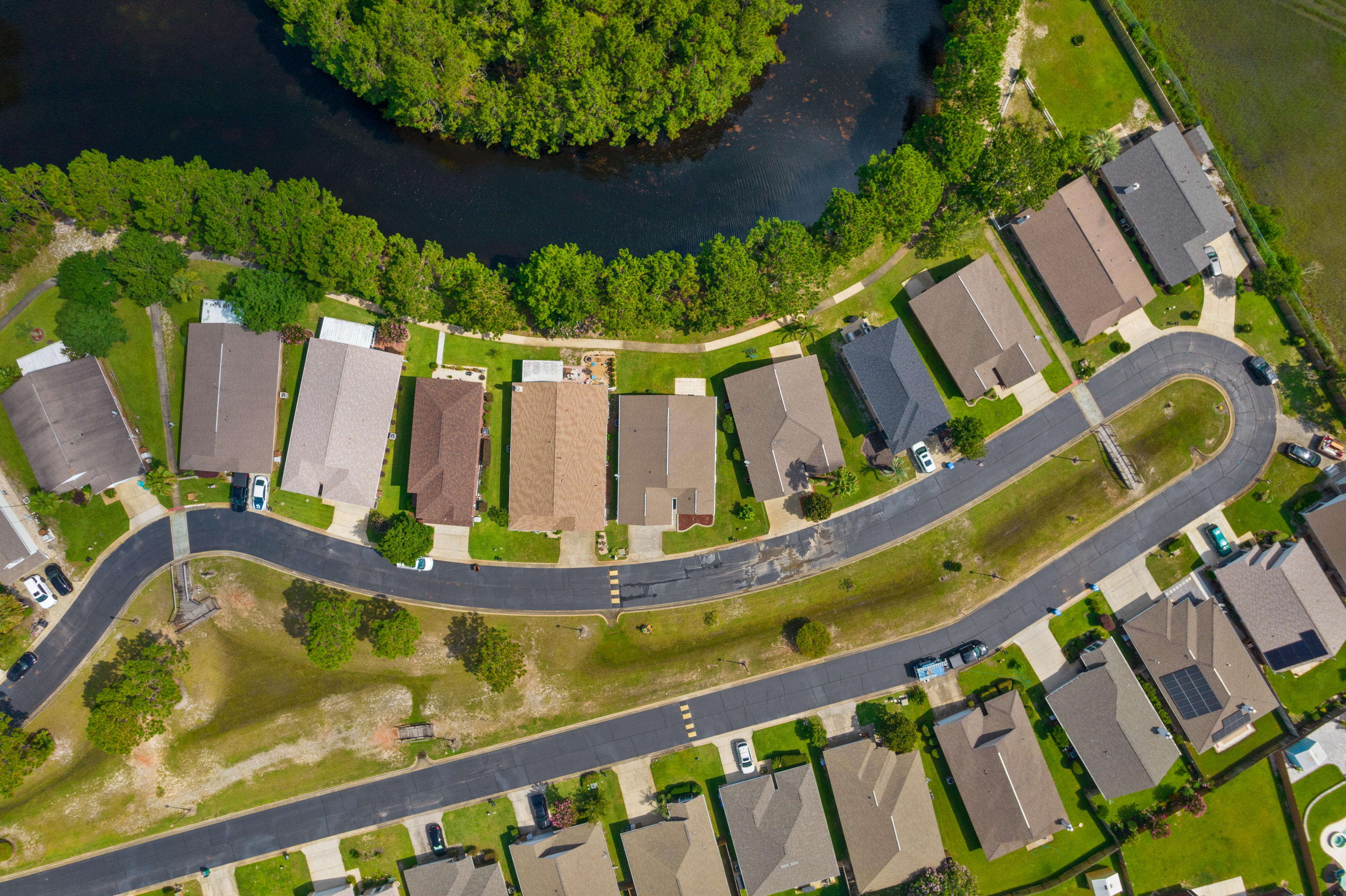Welcome to Parkers Landing, the gated subdivision that has lakes, a community pool and the closest commute into town. This home is located in East Navarre which is desirable especially if you are driving to Hurlburt Field AFB often. You will go North on Whispering Pines and follow the road back about a mile until you enter the gated entryway. Feel the security as soon as you pull. When you enter the home, you will notice the well kept curb appeal and the Lake views in the backyard with sidewalks and mature trees. Walk your pets or ride your bike throughout the community, and then go for a dip in the pool within walking distance of your home. This four bedroom, two bath home has an open layout for the growing family, or use the fourth room as an office.  CLICK MORE.......... The kitchen has crisp white cabinets and appliances. The stainless steel refrigerator will convey with the home as well. The thermostat has been updated too. There is zero carpet in this home for a cleaner feel. Don't worry about soiled carpet and padding from other homes when you can just move right in with throw rugs and your belongings! Tons of natural lighting come through with all the windows and back door to the Lake. This home is now vacant, cleaned and emptied for easy showings so you can move in quickly!!