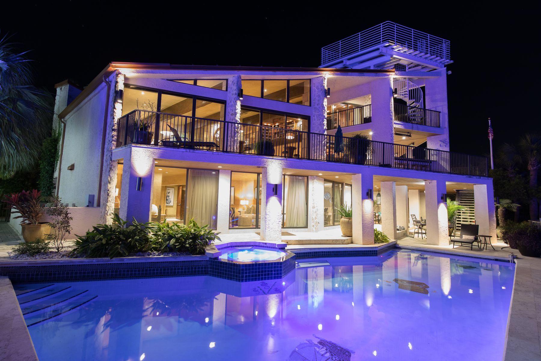 This 6-BR, 6.5-BA home on the Destin Harbor will check off all the boxes for the discerning buyer with a legacy home in mind. Merely entering the home inspires visions of family gatherings and entertaining. The most recent engineered renovation of this property topped $2 million. The craftsmanship is impressive with reclaimed heart pine flooring, open beams, custom stone floors and surfaces. Grand boating adventures begin right from home with the 4 boat slips and 2 jet ski lifts offering access to waterfront restaurants or the open waters of the Gulf of Mexico and Choctawhatchee Bay. Two slips are serviced by a central dock of nearly 100ft in length. The Ground Level offers a full kitchen, for ease of provisioning the boat, in and outdoor living and dining, swimming pool with lounge area, an optional Master Suite, two bedrooms, laundry, and three garage bays. The 2nd floor's open plan flows comfortably between the living room with gas fireplace, café tables, a wine cellar, commercial quality kitchen, lockout butler's kitchen/pantry, 2 dining rooms and expansive bar seating. The full-service outdoor kitchen supports al fresco dining, overlooking the harbor. The 2nd floor is rounded out by 2 guest bedrooms.  
The Grand Master Suite occupies the 3rd floor and emanates relaxation. One enters the bedroom through carved antique imported wooden doors to a spacious bedroom with seating area in front of a gas fireplace complete with Miele coffee bar.  A wall of windows highlights views of the harbor. The spa-like bathroom features 2 walk-in closets with laundry, a copper jetted soaking tub, dual vanities with copper basins and stone finished walk-in shower. This floor is complete with fitness room, an office/library and private terrace. Enjoy 360 views of the Gulf and Harbor with cocktails at sunset from the rooftop patio which spirals up from the third-floor terrace. 
The entire 7,500-square-foot home delivers luxury in thoughtfully selected light fixtures and floor to ceiling glass that invites the outdoors in as part of the decor. Electronic synchronized window shades complement the bulk of windows and glass doors. An elevator servicing all floors and a Smart Home system which controls security, 7 A/C units, lighting/sound and pool features, round out the features of this home.   A Private beach access for the Holiday Isle community is within easy distance with golf cart parking too. For those seeking to offset the investment with income, deep water boat slips are in demand, or the whole home can be rented as a grand vacation experience. This legacy home is now ready for a new family to gather their memories of celebration and grand adventure.
