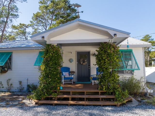 Location, Location, Location! Charming beach cottage just a few blocks from the area's largest public beach and leading to Rosemary Beach via a pedestrian tunnel and within reach of fantastic dining on 30 Avenue. Nestled on a beautifully landscaped, fenced in 1/4 acre, featuring a spacious screened porch, patios, and decks to enjoy the outdoors, this home is ready for you. Open, airy floor plan with hardwood floors throughout, this home is both charming and functional. The primary bedroom features a custom closet system and there is a full laundry adding convenience. The guest studio features a kitchenette and half bath, along with a second outdoor shower, expanding the property to a 3 bedroom. Located near the Lake Powell fishing dock and all the 30A area has to offer. Pets allowed with approval and pet deposit required.