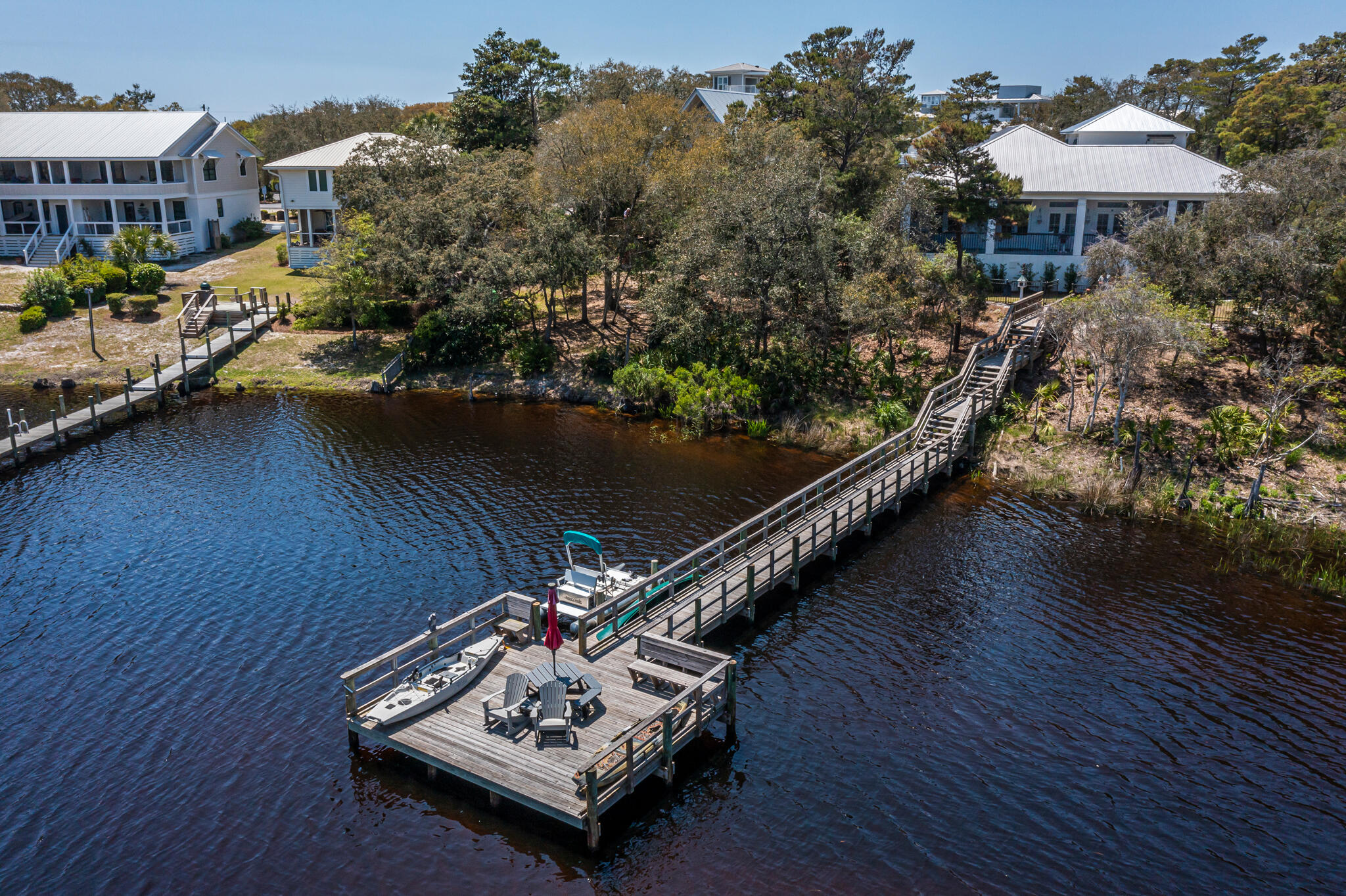 Beautiful Lakefront Property in the desirable Blue Mountain Beach Subdivision with NO HOA.  MOVE IN READY, it has been cleaned out and ready for its new owners.  This is a great house with lots of custom touches and would be a dream come true for any water lover.  A 3 tier pier dock on the Coastal Dune Lake with multiple deeded, private beach accesses in the neighborhood, plus a screened in, gunite pool.  The main home is 1916 sq ft and was built in 2018; it has 2 beds/2.5 baths and an 850 sq ft screened in, covered back porch with outdoor kitchen area.  There is an additional 506 sq ft Carriage House over the detached garage that was built in 2024; perfect for guests.  It is complete with 1 bed/1 bath; a living room/full kitchen combination, with both AC/Heat.  See the Property Flyer and list of Features in the Documents Section for additional information.  The Sellers are leaving the large gun safe that is in the air-conditioned room in the garage; the paddle boat, the canoe, the polywood table on the dock, and the heavy duty industrial grade- yet removable kid gate by the pool.