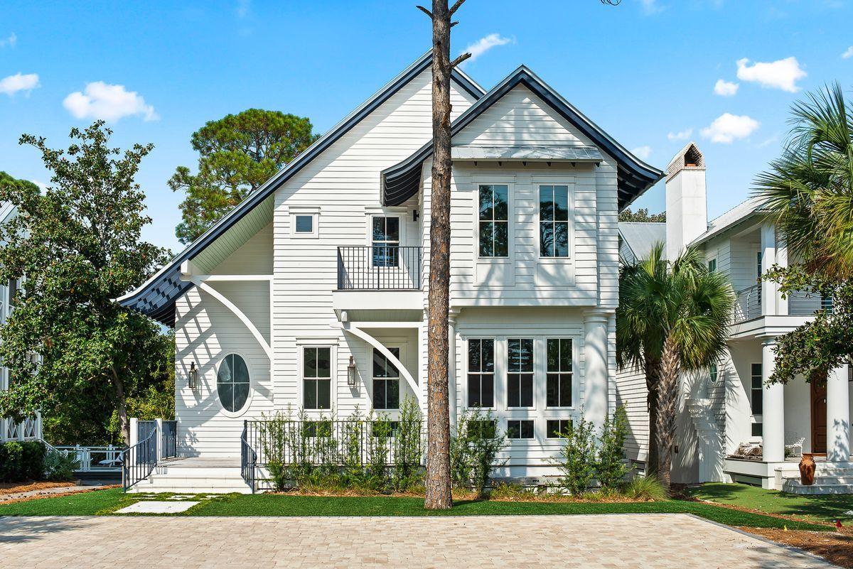 Just a few blocks from white sand beaches, this custom coastal home has been professionally designed and features several modern finishes. A 10 ft front door leads into an open living area with wood flooring, contemporary light fixtures, 12 ft ceilings, reclaimed wood doors, and shiplap walls. The slate tile fireplace in the living room is a unique focal point, and a spacious dining area and breakfast bar are perfect for large gatherings. The gourmet kitchen features Electrolux appliances, two dishwashers, a seamless slate tile backsplash, granite countertops, and soft close cabinets and drawers. Wet bar areas both downstairs and upstairs allow for easily preparing and serving cocktails. Offering 3,610 sq ft of living space, this home can easily accommodate larger families, making it an ideal primary home or vacation retreat. Three of four bedrooms are spacious enough to be considered master suites, with one located downstairs. The downstairs master offers a luxurious ensuite spa with a walk-in shower, soaker tub, and herringbone tile accent wall. Upstairs bedrooms include ensuite bathrooms and private balcony areas, and a hall bunk room provides additional sleeping space with four bunks. A secret door in the upstairs guest bedroom closet leads to extra storage space or a bonus room. 

Entertain outdoors with a screened-in porch with Epay decking. Remove the screens with just the touch of a button. The screened-in porch overlooks an L-shaped pool, sundeck, and large fenced-in yard. An astroturf front yard offers easy maintenance, and a paver driveway provides plenty of parking space. Situated on a beautiful wooded lot only three blocks from Seaside, enjoy living just a quick walk or bike ride from well-known shops, restaurants, and entertainment options, as well as Emerald Coast beaches.