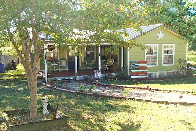 WATERFRONT -- BRING YOUR FISHING RODS!
This adorable cottage was one of the early fish camps on 620 acre Juniper Lake. You'll flip over the character and charm of this 2 BR, 1 Bath home. Completely updated with new plumbing and wiring in 2002, the house is styled with a vintage kitchen and exposed rafters in the living room. The property features a 10x24' barn with loft storage, a 16' deck to overlook the fabulous lake views, a double carport, and a relaxing covered front porch. The house has a metal roof and cement-board siding, a cozy propane fireplace in the parlor, a sunny dining room, and central heat & air. Property has 70' of waterfront. Fish from your dock, or there's easy access by boat to the main body of Lake Juniper which is full of brim, crappie, and large mouth bass!