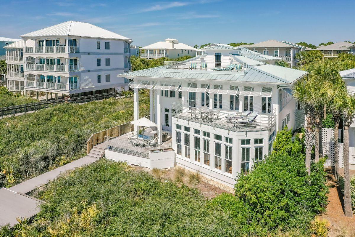 Offering an ideal location in Seagrove Beach, this gulf-front home features an expansive floor plan and panoramic water views. A true coastal retreat, this home has been well maintained and has been refreshed with white paint both inside and out. A private courtyard leads to the entrance, which then opens to reveal light, bright, and open main living areas that boast incredible views of the Gulf of Mexico. Prepare meals in a chef's kitchen with a beautiful coffered ceiling, two pantries, high-end appliances, double ovens, and a large island with room to seat eight. Perfect for entertaining, the home features a fully-equipped wet bar and large area for formal dining while French doors lead out to a spacious deck that overlooks emerald green waters. On the second floor, wake up to inspiring gulf views from an elegant master suite with its own private balcony. The master suite also offers its own office space, a walk-in closet, and a spa with a walk-in shower and Jacuzzi tub. Three more bedrooms offer luxurious accommodations and private en suite bathrooms. Additional features include extra storage spaces, a sauna, an attached carriage house, a third-level living space with a wet bar, and a rooftop deck for enjoying sunrises and sunsets over the water. No detail has been overlooked in the design of this sophisticated beach retreat, and interior finishes include a gas fireplace in the living room, built-ins, a private elevator, and touch panel blinds and Smart Home features managed by Enco. The home also includes hurricane glass/impact windows and doors, as well as a whole house generator and Ipe wood decking. Gather with family and friends for a beach getaway with plenty of space for parking, easy beach access, and dual outdoor showers for rinsing off sugar-white sand. This vacation home also offers access to a nearby neighborhood pool.