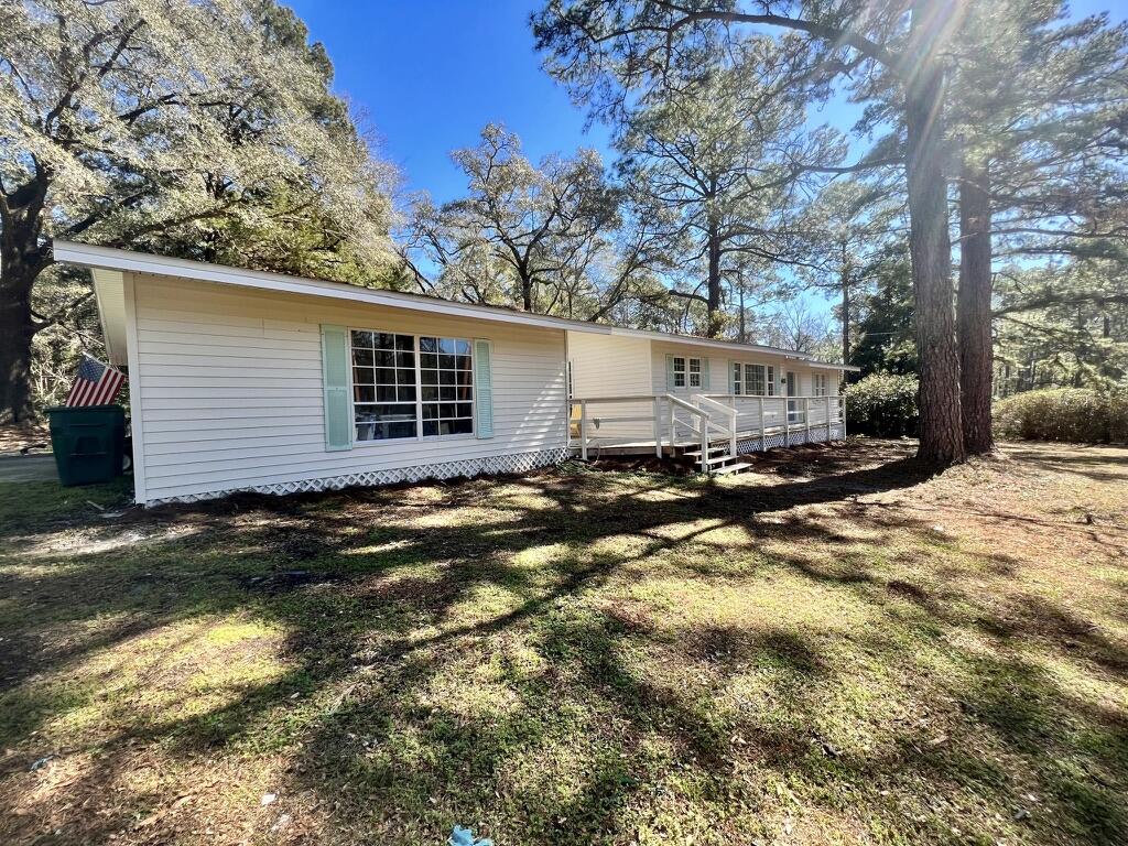 Completely RENOVATED. New: Electric, plumbing, A/C, flooring. Solid wood cabinets, granite counters. HUGE lot 1.27 acres. 3 large bedrooms, office area, foyer/mudroom, separate living and dining areas, 2 large bathrooms, spacious closets, one-level split bedroom plan. Finished Detached storage building off the covered carport. Large wooden barn/shed. walking distance to downtown DeFuniak shops, dining and Circle lake.