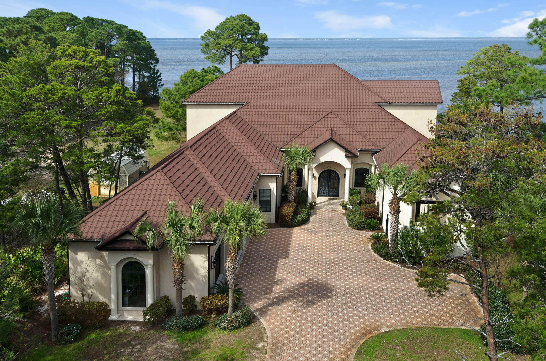 Take a drive down Walton Way in South Walton County. You won't see much more than private gates lining the estates' driveways along the bay. Only Walton Way offers the privacy of 100' of bay frontage, the tranquility of a cul de sac, and the meandering tree-lined driveways of deep lots. Welcome to 408 Walton Way. Built on a 1.15 acre, 500' deep, 100' wide bay front lot, this home is the ultimate retreat. Enter your electronic iron gate and take it slow down your designer pavers. Breathe in the bay air and smile proudly at your tropical foliage. Turn into your three-car garage and relax. You've arrived in your own personal paradise. You notice that the kids aren't home yet as their private wing is yet undisturbed. You take in the beauty of the intricate stonework in your gourmet kitchen and walk in your spacious pantry to consider your dinner options. It's always a pleasure to prep on your cook's island and then to sautÃ© on your 6-burner Thermador Range.  You grab a good bottle of cabernet from your wine refrigerator and head out to the 2000 square foot screened lanai. You consider a swim in the heated pool but decide that today is a better day to watch a sunset from your private dock on the bay. Back inside, you hear the family arrive. The sound of the opening of the wrought iron door, then the click of heals on the Brazilian Pecan hardwood floors bring a smile to your face. You slide back one set of sliding glass doors to invite the family outside and take in the drama that your 26' tall ceilings create. With over 5,300 square feet of heated and cooled living space, this Mediterranean style retreat allows for complete single floor living but the kids prefer to hang out upstairs. Today they watch a movie in the screening room instead of sunset from the immense covered balcony. You've thought of converting the upstairs to a guest suite since it has its own kitchen but you'll wait until the kids are gone from home. Days end draws you to the luscious master suite. Etta James' soothing croon fades away as you turn off the full house speakers. Another day in paradise. Another day at 408 Walton Way.  Make an appointment to experience this spectacular bay front estate today.