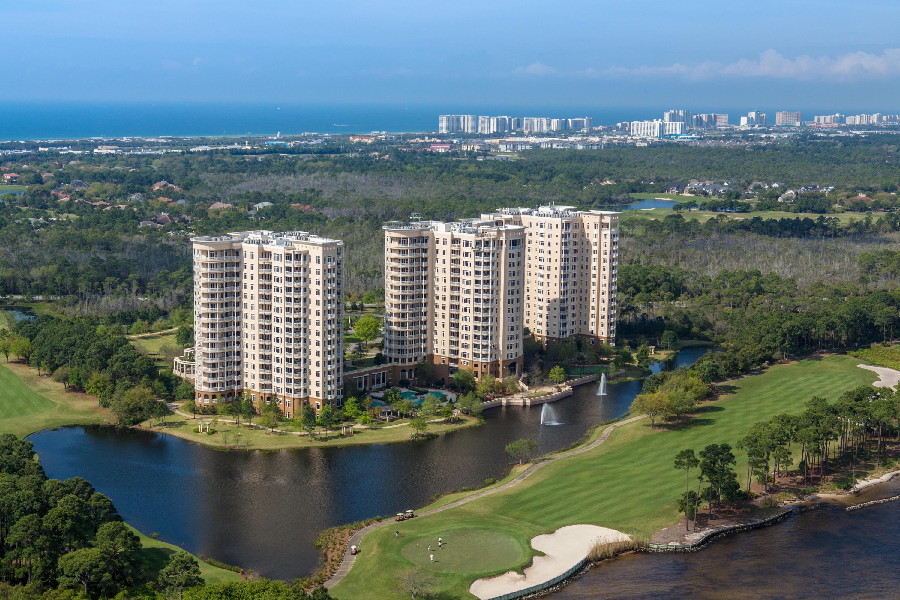 Luxury in the sky! Savor a stunning bird's eye view of the beauty of the Emerald Coast from this gorgeous One Water Place penthouse. Its desirable Castleton floorplan, featuring 3 bedrooms plus a large home office and wrap-around balcony, is enhanced by the 12' ceilings and greater privacy afforded by its top-floor location. The residence is excellently situated to enjoy views of the Gulf of Mexico, Choctawhatchee Bay, Fred Couples Signature Golf Course, and the abundant natural preserve land in Kelly Plantation.
As befits the amazing natural setting, the interior exhibits artistic flair and grandeur, combined with attention to quality and convenience. The floors are 18x18'' Turkish Marfil polished marble. Custom carved marble fireplaces provide a focal point in the living room and... master bedroom, while intricately carved columns embellish the formal dining room. Finish carpentry includes woodwork and solid core doors from E.F. San Juan, 11" baseboards, crown molding, chair rail and picture molding throughout, tray ceilings in the guest bedrooms, and a coffered ceiling in the office. Enhancing the architectural details, the lighting includes crystal fixtures in most rooms and rope accent lighting in the foyer, gallery, and primary areas, and dimmers on all ceiling light fixtures. The cabinetry is particularly notable, with custom pieces in the office and master hall, kitchen cabinets that extend to the ceiling, and exquisite Maitland Smith and Edgar Berebi crystal hardware. 

Highlights of the incredible kitchen include, but are not limited to, a huge island with 105" solid-piece granite breakfast bar; DCS 48" dual energy professional double oven and cooktop with 5 burners and griddle; a DCS warming drawer and microwave; Subzero fridge/freezer; Thermador dishwasher; 25-bottle dual-temp wine cooler; Manitowac ice maker; 44" chef's sink with double Koehler faucets; hammered stainless steel bar sink; pot filler; and more. Authentic mother-of-pearl backsplash and delightful fish drawer/cabinet pulls add a special shimmer. 

Condo living doesn't have to mean no grilling, especially with this patio kitchen. It includes a 36" Bull grill, a sink, cabinets with electrical power, travertine tile, and custom lighting. Many additional upgrades have been made beyond the standard level of One Water Place luxury, such as the 4'3" square and 32" deep master tub with a 85-gallon dedicated hot water heater, luxurious silk and velvet curtains, surround sound, and a camera/recorder in the foyer. Conditioned storage space located in the parking garage conveys as well.

For the times when you desire to descend to earth, this property is being offered with an assigned golf cart space and a custom-made, street-legal golf cart, allowing you immediate enjoyment of One Water Place and Kelly Plantation's abundant amenities, as well as the many attractions of Florida's beautiful Emerald Coast!