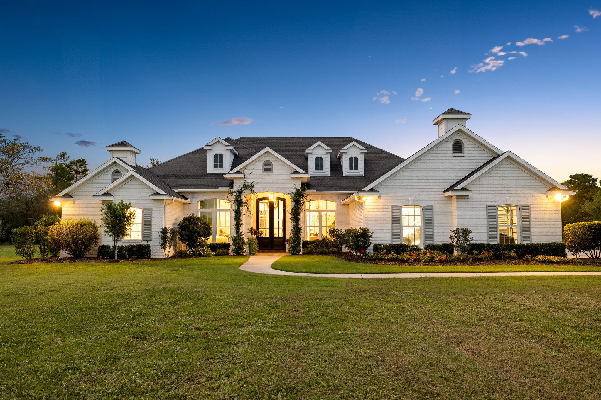 Discover the perfect blend of privacy, luxury, and estate living in this sprawling 4,625 square foot home, set on over 5 acres in the exclusive Windswept Estates community. Architecturally striking and flawlessly designed with 12' ceilings, this 5-bedroom, 5.5-bath residence offers a seamless flow for effortless living, making it an ideal option for both primary and secondary homes. Fully renovated with a brand new roof (11/24) the home's interior boasts contemporary coastal influences with high-end finishes, premium appliances, and abundant natural light.

The thoughtful split layout includes multiple living areas designed for seamless flow and entertaining. The chef's kitchen including a cozy breakfast nook, features a 48-inch Wolf range, marble waterfall island, and designer lighti which is both functional and inspiring, all overlooking the tranquility of the pool and green spaces. The family room is designed for everyday living, offering a comfortable space where everyone can gather for quality time, whether it's playing games, doing homework, or just relaxing together. Its open, central location allows for easy interaction between family members, making it a true hub of daily activity.

The formal living room and dining room with adjoining butler's pantry are filled with natural light awaiting laughter and memories to be made in their spaces.

The gorgeous home office with antique reclaimed wrought iron doors embraces a tranquil place to handle life's business while the oversized master suite combines natural wood ceiling accents, showcasing a balanced design meant to be appreciated.  The ensuite primary bath features a spacious shower, soaking tub, dual vanities.  All closets have an abundance of storage.

Transitional spaces prioritize indoor-outdoor living, offering generous opportunities to enjoy the 19x38 pool, complete with peacock paver patio and tranquil water features. The motorized screens allow you to enjoy the breezes but not the bugs on the covered porch.  The white-painted brick exterior adds a fresh touch to the timeless architecture, while the primary 3-car garage provides ample storage for multiple vehicles, golf carts, and beach gear.

A charming carriage house, complete with a separate entrance, offers a cozy sitting area and kitchenette and sleeping quarters with private bath, the perfect space for multigenerational living. This private retreat allows family members or guests to enjoy their own independence while still being close to the main home.  
The adjacent two-car garage adds additional privacy for the occupants of the carriage.  Whether it's for extended family visits or as a long-term living arrangement, the thoughtful plan provides a comfortable, self-sufficient space with all the conveniences needed for seamless living.

486 Coastal Breeze sits on over 5 acres of well-maintained grounds.  Fenced and gated, the estate offers plentiful parking inclusive of a motorcoach pad.

Situated in the 750-acre Windswept Estates, a master-planned community with a five-star golf course, this stunning estate is just 15 miles from the sugar-white sands of Walton County's beautiful beaches and sits in the midst of one of the fastest-growing cities in Florida.