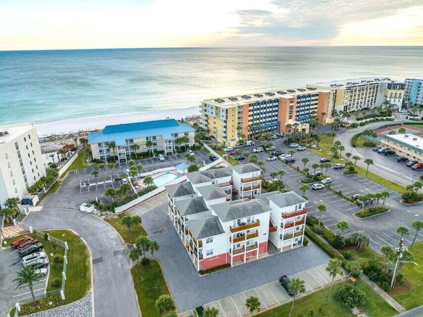 Experience Gulf-front living on Okaloosa Island—just a 60-second walk to the beach. This professionally remodeled 2-bed, 2-bath furnished condo features all-new bathrooms, new flooring, and a rare private one-car GARAGE large enough for a full-size SUV—an exceptional find on Okaloosa Island. Sunset Cottages is a low-density community of only 19 units, offering peaceful, uncrowded beaches and stunning sunsets.

Both bedrooms have private balconies with breathtaking Intracoastal Waterway views, while the open living area and kitchen overlook the pool and access an additional balcony through double French doors. Just minutes from the Gulfarium, the Gulf Resteraunt, and the Destin Harbor.