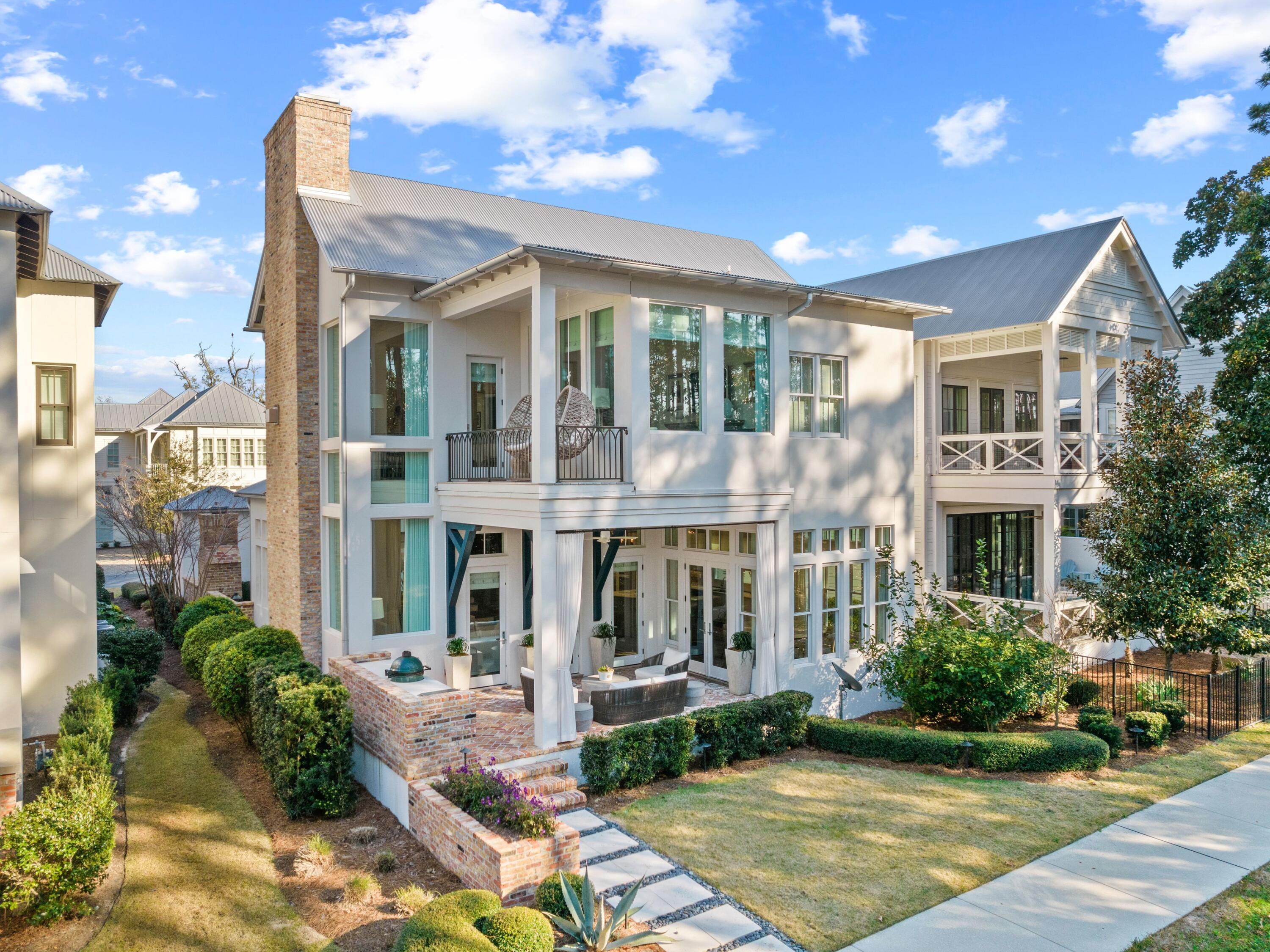 Thoughtfully curated interiors pay homage to nature in this 4,160-sq.-ft. home in the sought-after waterfront neighborhood of Churchill Oaks. Boasting four beds, four-and-a-half baths, a two-car garage and 12-ft. ceilings throughout, this contemporary residence also includes custom-stained sawn oak floors throughout and purposely placed windows that frame the surrounding pine trees outside. Beyond the custom wood entrance gate with security access, the home will delight your senses with reclaimed Chicago brick pavers, modern cabinetry, mantels, and shelving, including a custom, glass-walled wine cellar capable of holding 2,000 bottles. The well-appointed kitchen is dressed with Nambian marble countertops and outfitted with an induction cooktop, double ovens with warming drawer, three dishwashers, curved breakfast bar and a Galley sink with dual commercial-grade faucets. An adjacent butler's pantry is ideal for storage and concealing additional appliances. The comfortable living room is home to one of three fireplaces in the house, with the others located in the owner's suite and outdoor living space. A wet bar area features an ice maker and beverage cooler. The masterful owner's suite is marked by a freestanding partition as the room's centerpiece and a gas fireplace. The en suite bath has luxurious marble flooring with white cabinetry, claw-foot tub and crystal chandelier. A glass-enclosed steam shower is lined in Carrara gold marble, while Nambian marble sits atop the counters. Hallmarks of the home's exterior include a smooth stucco finish, summer kitchen positioned under a covered veranda and two-car garage. Additional notable features of this property are a whole-home generator, whole-home water purification system, Rinnai tankless water heater, two HVAC systems, and a security system with interior and exterior cameras. Churchill Oaks is ensconced in quiet grandeur while still remaining near all of the amenities South Walton is known for. One of the most exclusive communities in Walton County, it features a generous infinity-edge pool, clubhouse and marina positioned right on Choctawhatchee Bay.