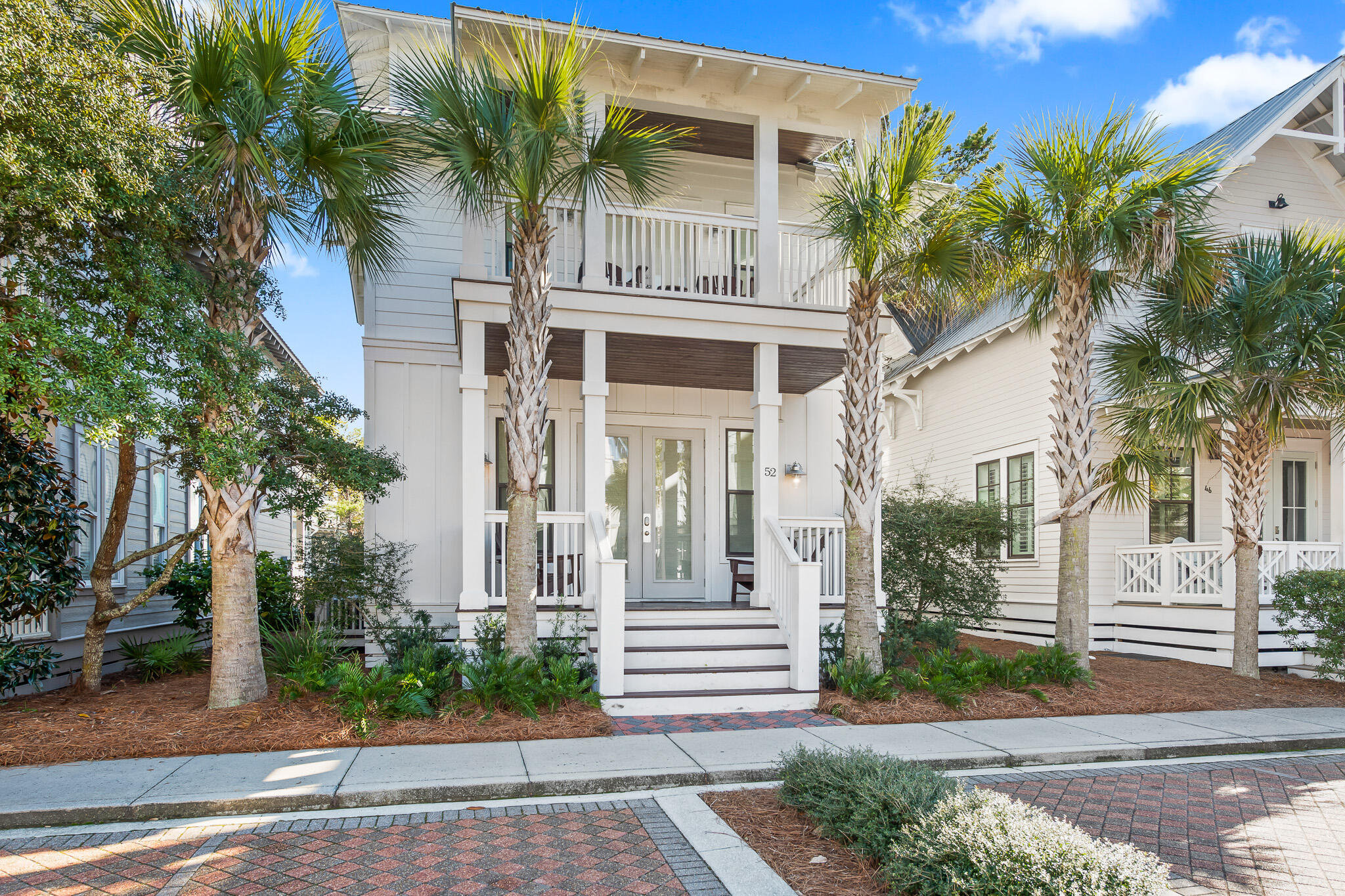 Sophisticated decor and a thoughtful floor plan, combined with a stellar location within Seacrest Beach, make 52 East Seacrest Beach Boulevard the ideal beach home.  Spacious porches and balconies on every level create beautiful curb appeal, and the interiors are comfortable and inviting.  The entrance to the legendary Seacrest Beach lagoon pool is less than fifty feet from the front door, or catch the tram to the beach at the pick-up one door down.

Once you're inside the home, you'll find an inviting ground floor with a large, open floor plan, including a chef's kitchen with a large island, farmhouse sink, ample bright quartz countertops, and ceiling-height cabinetry. The dining table seats eight, with room for four more at the bar, or relax on the comfortable sofas and chairs in the living area.  Also on the ground floor is a large bedroom with en-suite bathroom, a separate half-bath, and a large closet for additional storage.

The second floor is home to the primary suite, which opens to a private balcony overlooking East Seacrest Beach Boulevard.  The primary bathroom features a double vanity, large glass shower, and a large, lockable owner's closet for convenient storage while you're away.  A second guest bedroom, also with en-suite bathroom, overlooks the rear of the home, and a four-bed bunk room, also with en-suite bathroom, is a charming place for even more guests.

The third floor, which could double as a second primary suite, has a large bedroom with an artisan-crafted ceiling. A wet bar at the top of the stairs, with mini-fridge, counter space, and cabinetry, opens to the spacious covered deck, where you can catch a breeze and listen to the Gulf.  A newly-constructed grill installation flows with the superior decor found throughout the rest of the home.

As an added bonus, the home has seven deeded parking spaces (four in front and three in rear), a rarity in bustling Seacrest.  The outdoor shower in the rear of the home lets you and your guests rinse the sand from your toes after a day enjoying the beach, the pool, and all the other amenities of Seacrest Beach and 30A.