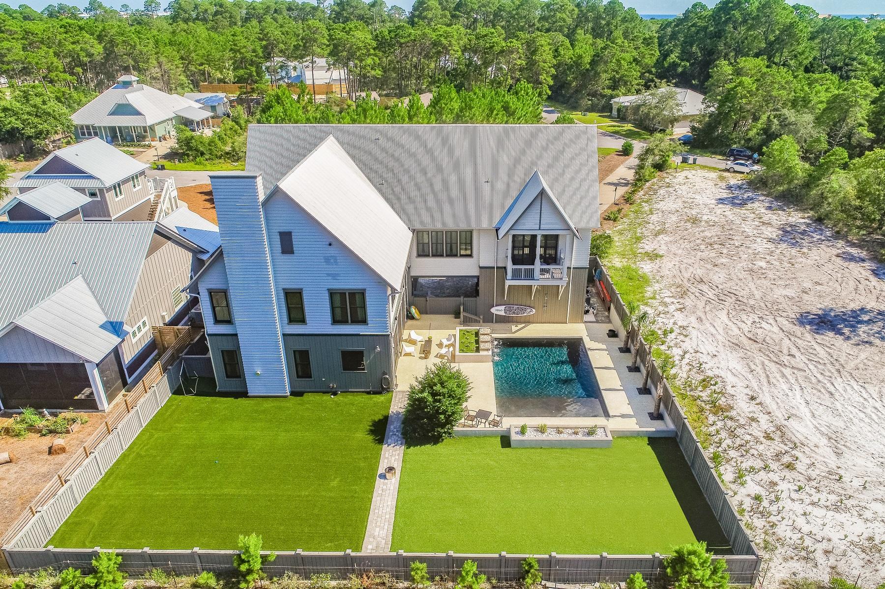 Custom designed luxury home located in the quiet part of Seacrest. This pristine home offers 4400 square feet of living space plus a resort styled pool that opens onto a large private fenced yard for pets to roam! This stunning property offers privacy against the backdrop of the magnificent state forest. Immaculately maintained, this Grand Bay build is designed for full-time family living or vacation/second home. Easy beach access is nearby. 
This large stately home with architectural details on all exterior sides is graced with a long drive way in. 
The interior offers an upscale coastal palette with gray cabinetry and whitewashed wide plank flooring. Abounded by natural light throughout, the clean modern kitchen features white quartz countertops, Thermador appliances, convection oven, two dishwashers and stainless farm sink with touch-less faucet. Custom features include cabinets to hide and easily access countertop appliances and a ladder for hard to reach upper cabinets.  
The kitchen opens to the dining and living areas. Accented by a soaring 25 foot vaulted ceiling, the
 dramatic fireplace extends to the top of the masterfully built wood arched beams. You'll feel right at home! This wonderfully comfortable and versatile room opens onto a large screened patio and summer kitchen. Open the two extensive Nano accordion door window systems to create one magnificent entertainment area, complete with outdoor Viking oven, DCS grille, sink and refrigerator. 
The large private fenced backyard features a stunning oversized saltwater pool with bubblers, umbrella holder and rock water features. The wrap around pool deck with gas fire pit is designed to accommodate.   
The mud room with half bath offers built-in lockers and cubbies to hang jackets, store bags and shoes. The office workspace with sliding barn doors completes the first floor.   

The second floor showcases a large, light filled flex room providing an ideal place for family lounging, studying, or TV. This creative spacious area will be so enjoyed by the family. 

The master bedroom occupies an entire wing of the second floor with its own AC unit. Highlighted by a vaulted ceiling, you'll enjoy the seasonal flowers and an occasional family of deer prancing thru the expansive state forest from your master bedroom private balcony. The master bathroom was featured in Beautiful Kitchen and Baths magazine. Dual vanities with custom light fixtures, a separate tub, and huge walk-in dual shower welcome you. A nice walk-in closet with custom built ins completes the master area.   

The second floor offers a guest bedroom, guest bathroom with shower, built-in desk area, laundry room with sink & storage.  

Anchoring the third floor are two comfortable guest rooms and a full bath with double sinks in the middle.  
A propane gas system fuels the Napoleon fireplace, Rinnai tankless water heater, fire pit, and appliances. Four AC zones & compressors climatize the property. Millwork by EF San Juan. The long driveway and garage can accomodate several vehicles. 

This lower density Seacrest neighborhood is a rare find on east 30-A and is so convenient to Alys Beach and more! All square footage and room dimensions are approximate and should be verified by the buyer. An absolute stunner in Seacrest awaits!