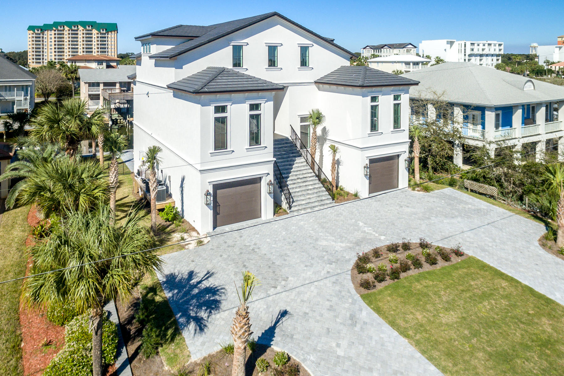 Spectacular waterfront estate in Destin, Florida's exclusive waterfront community of Holiday Isle! This luxurious residence offers approximately 80' of navigable, deep-water, and is only one canal from the coveted Harbor, featuring a wonderful array of restaurants and entertainment. The nearly -1/4-acre prime lot accommodates a 15' x 35' heated, saltwater pool, with an additional 7'x11' wading lagoon, all serviced by an exterior, covered summer kitchen.
Measuring approximately 5,577 SF, and three stories, all of which are serviced by an elevator, this newly constructed residence is the ultimate family compound with exceptional structural integrity and superb features and finishes throughout, not the least of which includes the following: stately circular drive servicing two... enclosed garage bays, fabulous custom-forged iron entry doors, beautiful wood plank flooring and millwork, gorgeous quartzite countertops, extremely spacious rooms, exquisite tile selections and baths, fine plumbing and electrical fixturing, custom cabinetry, extraordinary kitchen with a huge, concealed walk-in pantry, Sub-Zero refrigeration, 6-burner dacor gas cooktop, griddle, and dual oven. The enormous living room, which contains 12' ceilings, casts an unmistakable Zen and ambiance, not only from its contemporary gas fireplace and surrounding white chip-edged accent wall, but also the pleasant view.  The laundry room is even spacious, offering an abundance of countertop and cabinet space, together with a utility sink. The private master retreat on the third floor is one of the finest, offering spectacular views, covered balcony, vaulted ceilings, study or Yoga/fitness studio, stunning bath, and a massive three-room closet configuration with a shoe salon, truly unrivaled in most respects. Your guests and children will be enamored with the accommodations in the guest suite, which includes a large, private bedroom with a sitting area and full bath, and other areas that include a media room, game room, fitness studio, and bunk room. All mechanical systems utilize extremely efficient technology, including LED recessed lighting, three HVAC units, and a tankless gas hot-water heater.  The hardscaping elements accentuate the lush and irrigated landscape. The property is spectacular!  Please inquire for further details.  Buyer must verify all information and specifications.