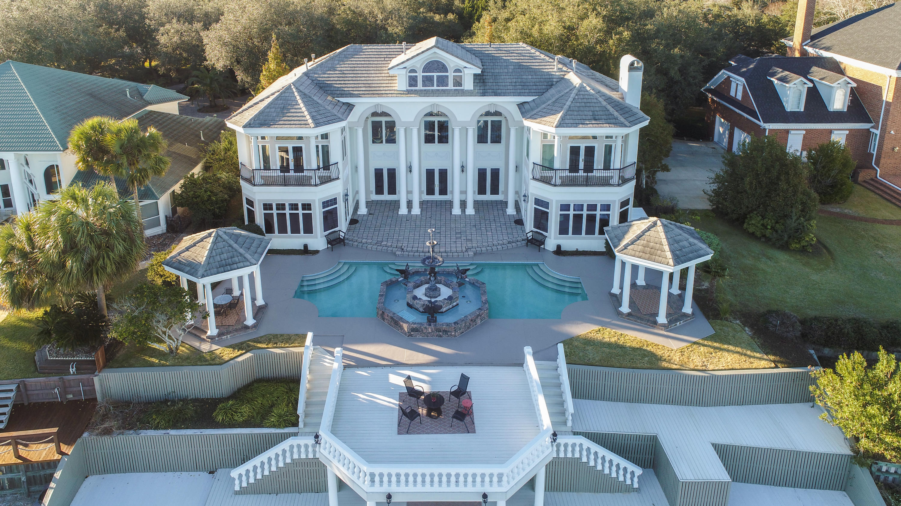 This extraordinary waterfront estate sits over twenty feet high on a bluff overlooking Choctawhatchee Bay. Enjoy panoramic views of Okaloosa Island to the south, Destin to the east, and Niceville to the north. Aged oak and cypress trees line the driveway to the majestic porte-cochere, and a large koi pond with a waterfall captures the serenity of the setting. Oversized arched double doors welcome you to the heart of the home--the main living space that has soaring 30-foot ceilings, a winding staircase to the second floor, and double-sided fireplace encased in a handcrafted wood mantel. This residence's appointments are exceptional: hardwood floors, deep crown molding, faux painting, custom cabinetry, arched doorways, five fireplaces, surround sound, palladium windows, exquisite lighting and art niches.  The kitchen has a fireplace, double ovens, center island, gas cooktop, sub-zero refrigerator, large butler's pantry, and casual dining area.  The kitchen flows into the spacious family room which has a fireplace flanked by custom built-ins.  The den doubles as the billiards room and has a fireplace, wet bar, refrigerator, ice maker, and built-in cabinets. Also located on the first floor are two bedrooms, two bathrooms, and laundry room.  The second floor consists of the lavish master suite on the north side and office space on the south side.  The master suite has a double-sided fireplace, private balcony, Jacuzzi tub, walk-in shower, and separate, double dressing areas.  A spacious office suite offers ample space to conduct business and plan for success.  Adjoining this space is a large room that could be used as additional office space or as another bedroom.  The third floor offers additional office/hobby space, a combined living/dining area, fireplace, and bedroom with bathroom. The waterfront side has a magnificent fountain in the center, bordered by the pool and surrounded by pavers.  Two gazebos flank each side, and a sun deck provides ample space to enjoy the best coastal lifestyle possible.  At the water's edge you will find a spacious covered porch and a pier that houses a dock and boathouse. A three-car detached garage is air-conditioned, and one bay has been finished out to provide additional living space. This home is perfect for entertaining and brings an elegance to coastal living that is rare to find. This home comes mostly furnished.  Kacy Turpin Interiors has provided exceptional artwork that can be purchased as a group or individually.  All information and dimensions including square footage are to be verified by the purchaser.