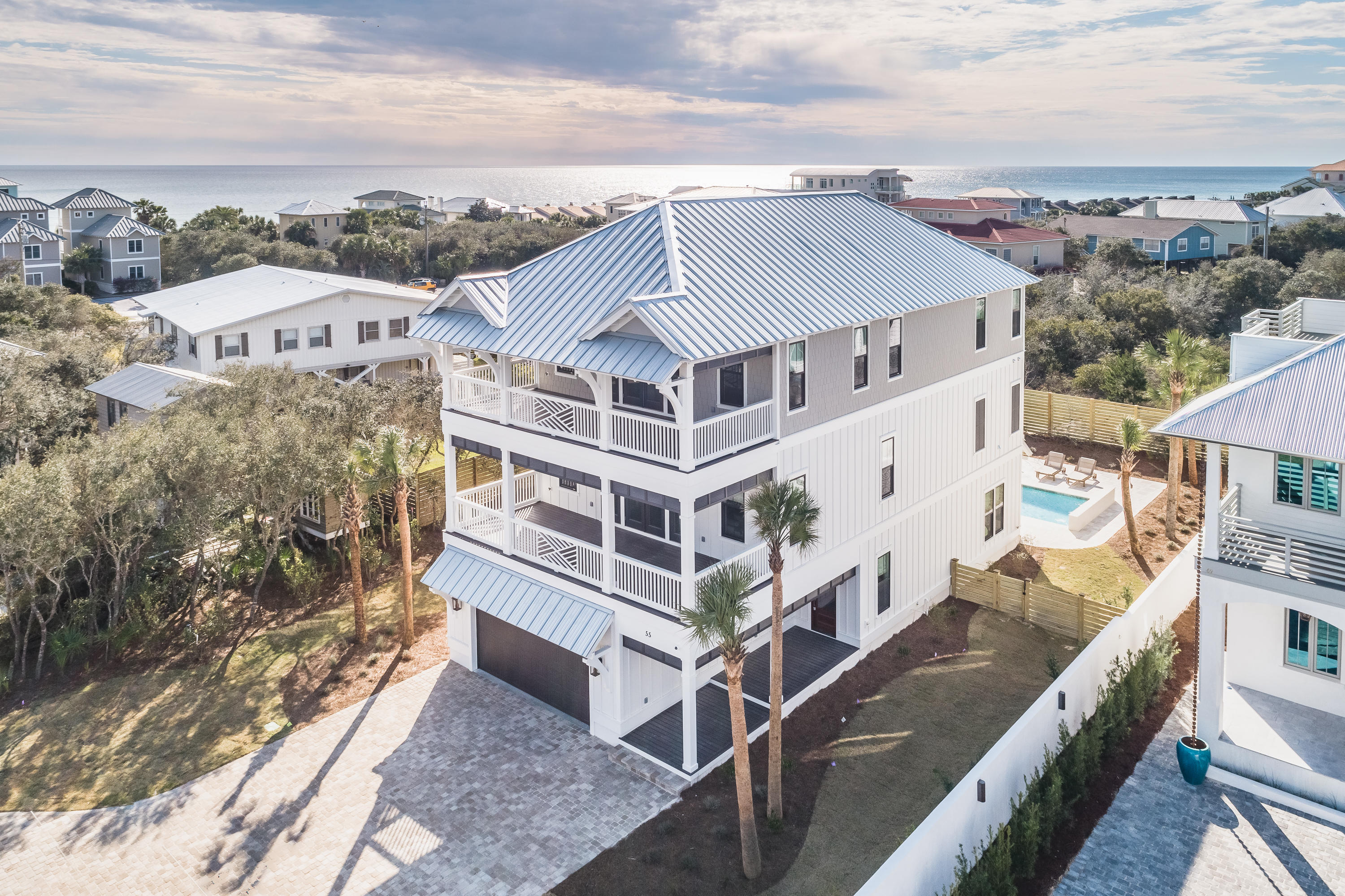 Welcome to coastal luxury living in this newly constructed house located in the heart of Seacrest Beach with deeded beach access at Green St! This home features 5 bedrooms, 5 full baths/2 half baths, along with numerous amenities for you to enjoy the perfect beach life. The house has three stories, two of which have amazing gulf views. The first floor living area overlooking the pool is a great place to enjoy winding down at the end of the day. The beautifully appointed kitchen located on the second floor has all Thermador stainless steel appliances, quartz countertops, custom cabinets, 2 dishwashers, and even a refrigerator that will open and close itself.
Not only is the house itself stunning, but the outdoor area will be the envy of everyone. It features an outdoor shower and covered outdoor kitchen complete with a bathroom, seating area with fireplace, Blaze grill, separate pot burner, sink, and beverage center.  There is a heated salt water pool with a large deck to allow outdoor entertaining year round.  From the beautiful furnishings to the gulf views, this house is truly spectacular!