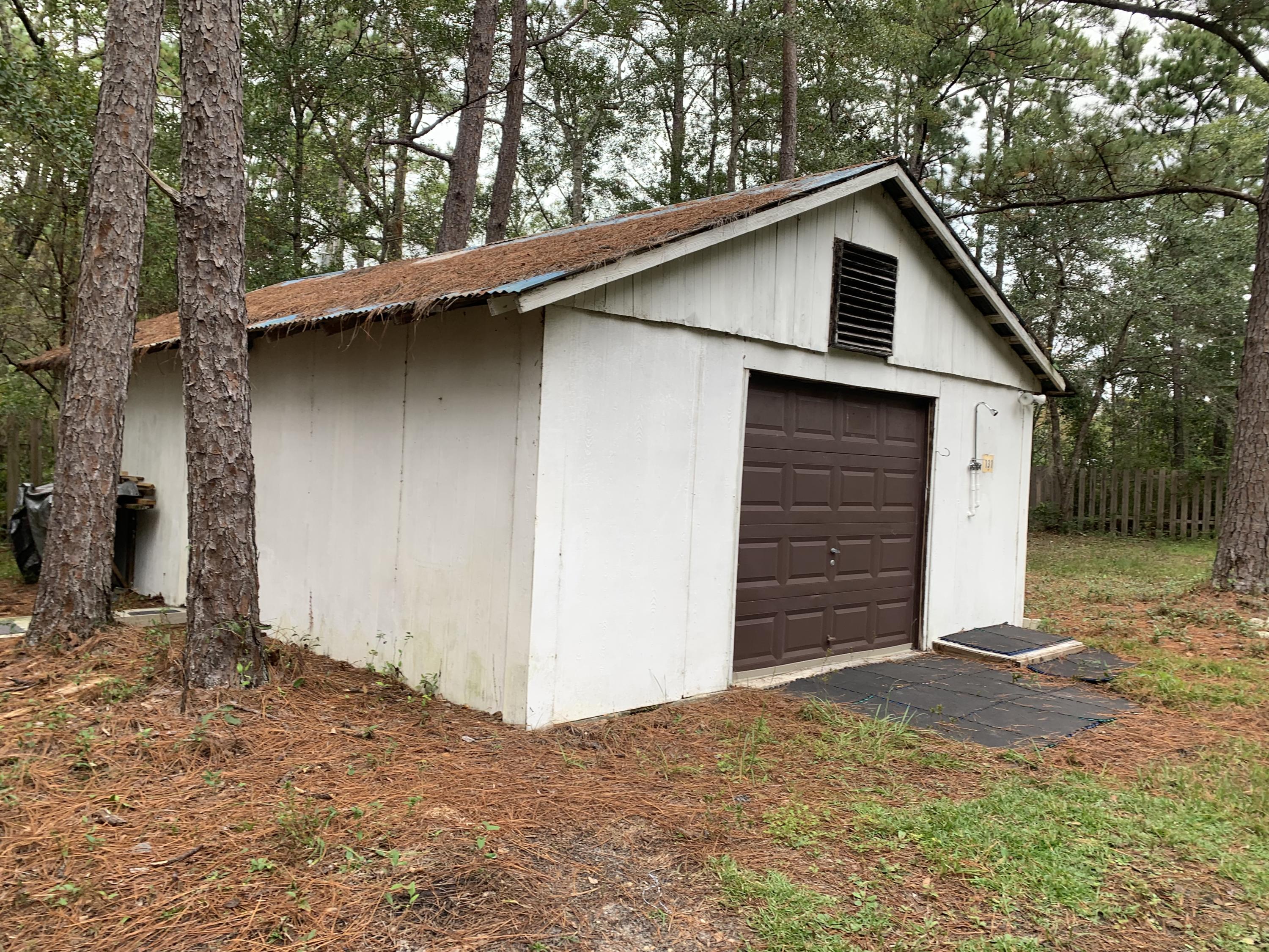 Secluded and privacy fenced property with gate, power and city water. Close to Boat Launch at Black Creek and new Bayfront Park at the 331 Bridge.  Only 15 minutes to Beaches of South Walton!  Unrestricted property ready for weekend get-away or site for new residence!  There is also a garage with overhead garage door, window-type A/C, water heater, and refrigerator with ice maker. Property comes with 2005 travel trailer but was not given value. It has a functioning window-type A/C, new RV battery, and portable heater. There is no septic tank on the property. Property has mature trees and owner has kept the grass mowed and maintained.  Must See to appreciate.
