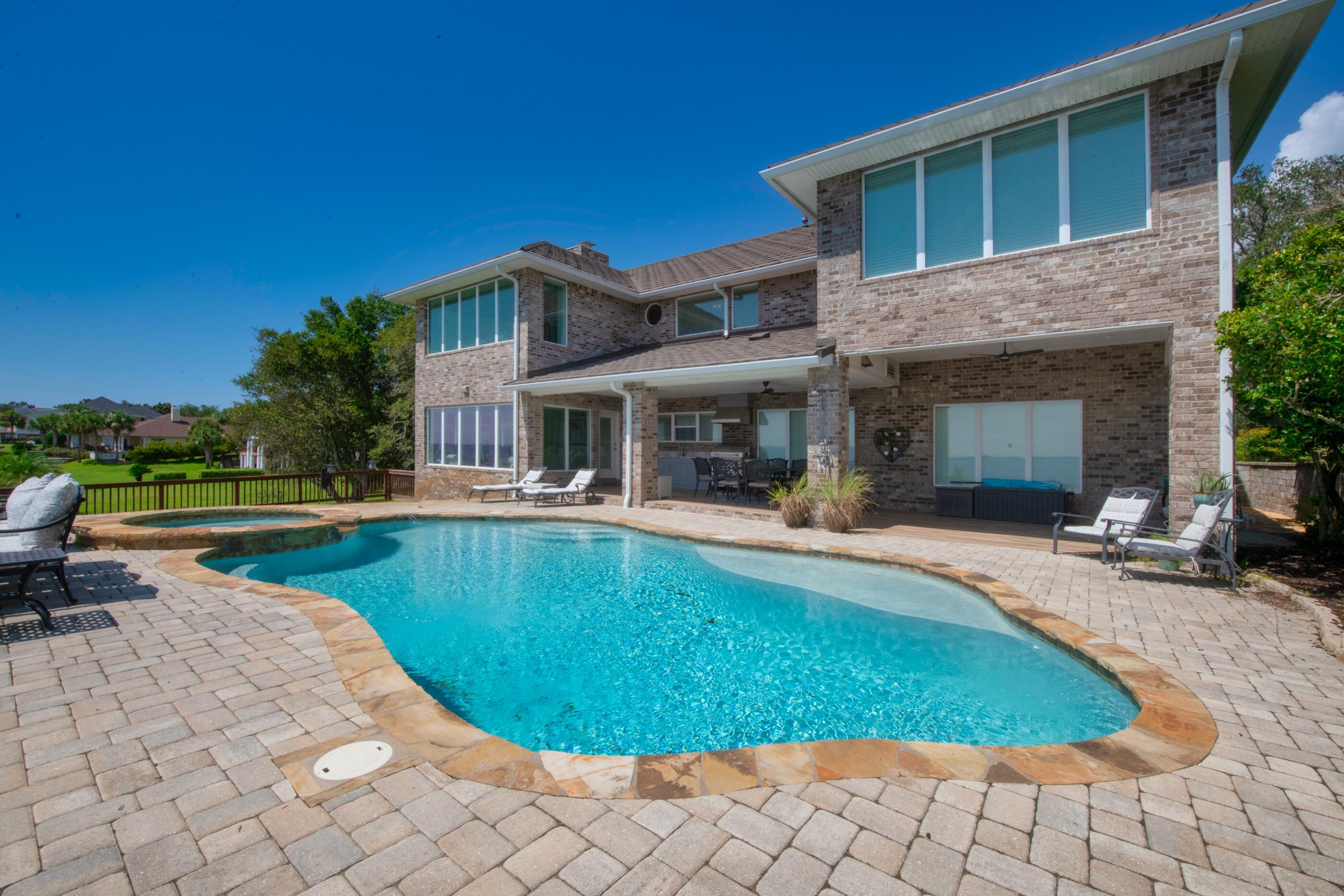 Is it your dream to live on the water?  Then this could be the home for you!  Situated on the Bluffs across the street from the 18th hole of Shalimar Pointe Golf Course, with possibly one of the best views on Choctawhatchee Bay. The home is gorgeous both inside and out.  The entry way opens to a large formal dining area with beautiful, panoramic views of Destin. There is a gourmet kitchen with a large breakfast bar and tons of cabinet space.  Relax and enjoy the views from every angle in the sunroom, or you can entertain guests in the spacious theater room.  There is one bedroom complete with its own bath on the main level as well as a half bath.  Upstairs you will find the huge Master Suite, complete with a massive walk-in closet, fireplace and sitting area that overlooks the water.  Two additional large en suite bedrooms, all have breathtaking views of the water, along with an additional office/nursery room and an extra laundry area.  The backyard offers a pool/spa, outdoor kitchen and plenty of entertainment space. A huge over sized garage with a ton of additional parking space.    There are truly too many options to list for this home, a must see!!