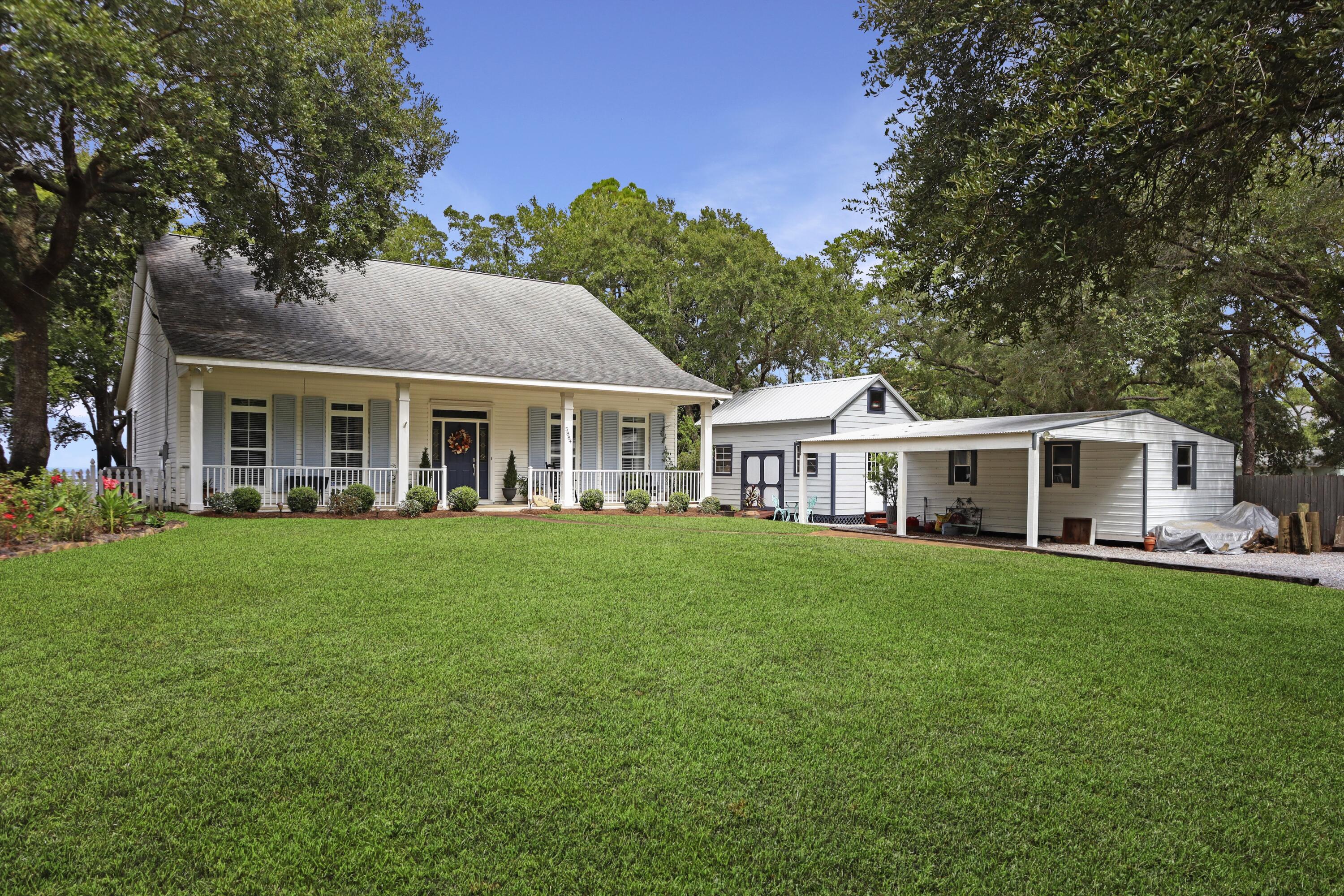 Introducing Bay Haven Cottage, where New England charm meets Gulf Coast ease. Gated and set high on East Bay, this waterfront jewel enjoys about 100 feet of frontage and nightly sunsets from a 44 ft by 12 ft deep screened porch. Inside, real hardwood floors connect bright living and dining spaces with crown molding, recessed lighting, and volume ceilings. The bay-view kitchen offers island storage, bar seating, and under-cabinet lighting. The primary suite faces the water and tile-inlay shower. Outside, enjoy a 120-foot dock with stairs, 8,000-pound lift, seawall, and riprap. Practical perks include a 2014 roof, 2018 HVAC, irrigation, gated entry, two workshops with carport, and 0.71 acres. All minutes to beaches, shopping, Pensacola, and Destin.