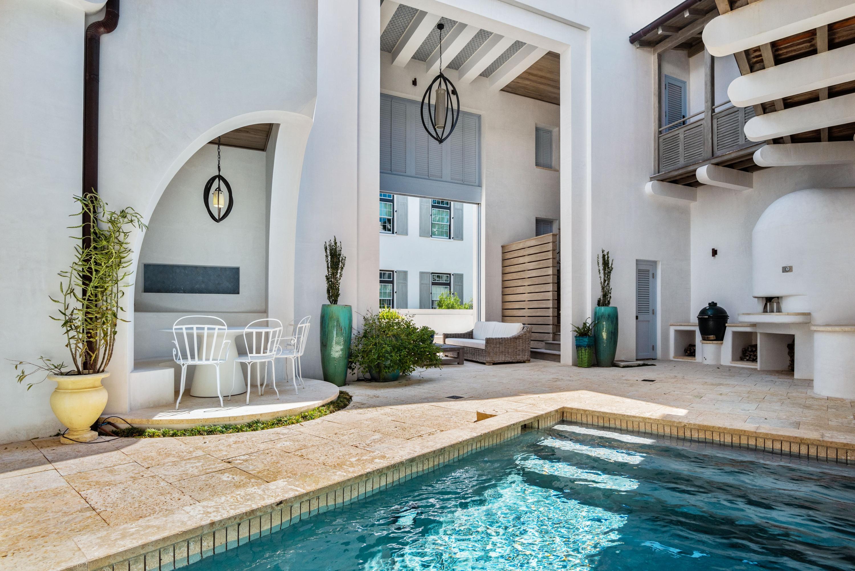 Surround yourself in modern luxury at 52 Butterwood Aly, a premier property in the enchanting neighborhood of Alys Beach. This 4,875 square foot Gary Justiss designed home encapsulates the iconic styling of the community, while custom features from high-end craftsman create a truly unique experience throughout the home. Upon entry, residents are welcomed to the refreshed white stucco exterior home through the custom illuminated entryway. Designed with easy living and entertaining in mind, the chef's kitchen provides an inspiring space, accented by the venetian plaster and Dominican shell stone appearing throughout the first floor. Curated living spaces shine throughout the three levels of this home, providing a collection of open areas as well as tucked-away refuges exuding the bohemian influences which Alys Beach was founded upon.  A collection of custom tile work in the four full and two half-baths inspires, while articulated millwork from EF San Juan and fixtures from Dornbracht and Waterworks exude tasteful grandeur. White oak flooring is showcased throughout the second and third stories, while simply stunning outdoor spaces are featured on the first and third floors. The ground level courtyard creates a focal point for lively gatherings, highlighted by an artisan plunge pool, Earth Stone brick oven, and continuation of shell stone pavers. The third floor loggia provides sunlit relaxation and views of neighboring Lake Marilyn. Additional features include a Control4 home smart system, Sub-Zero and Miele Appliances, Sonos audio system and a two car garage.