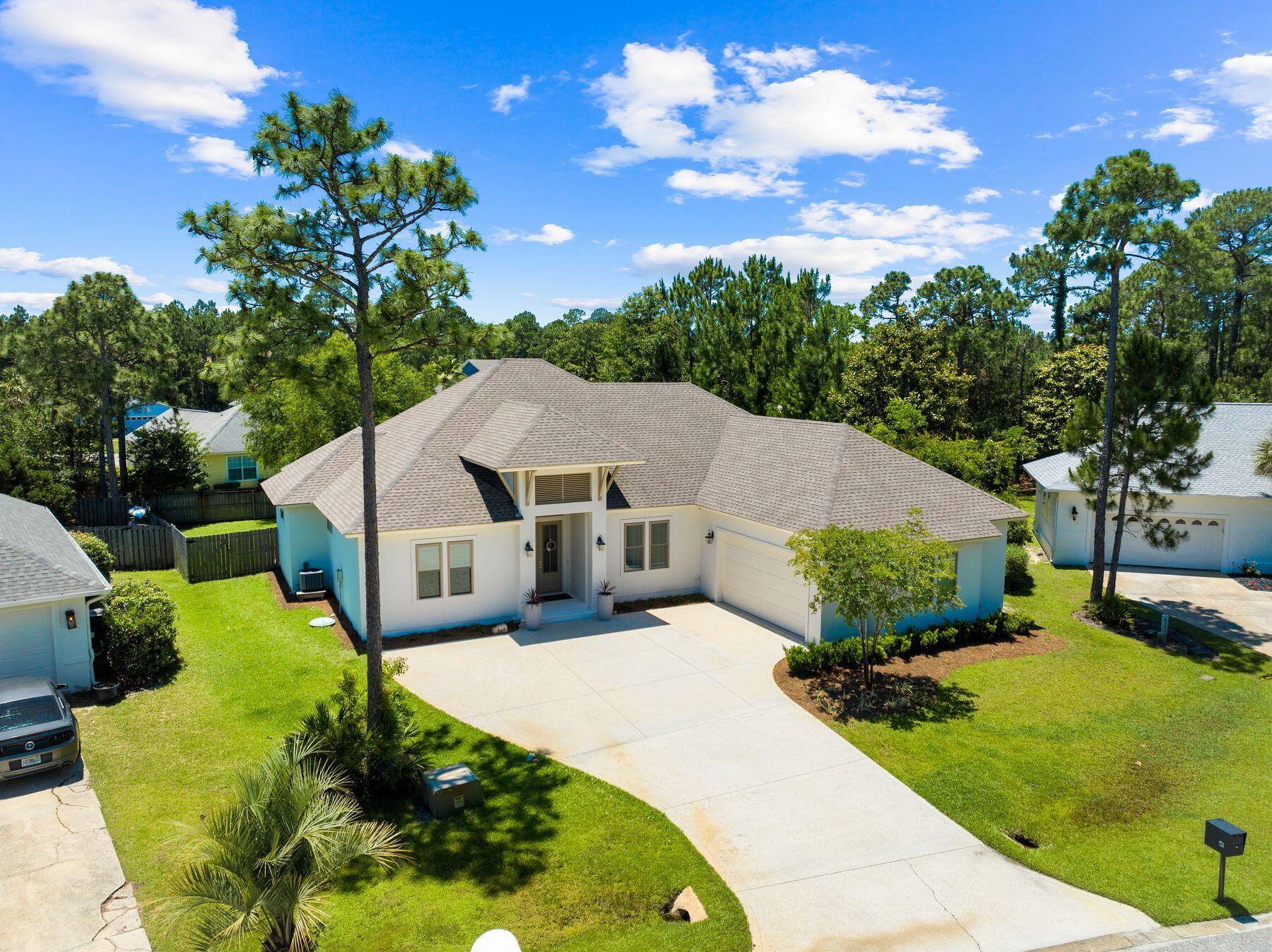 Introducing 51 Morning Sun Court, a beautifully crafted four-bedroom, three-bathroom home that perfectly blends luxury, comfort, and thoughtful design. Built in 2019, this custom single-level residence is located in the sought-after and rental-restricted Pelican Bay community--just minutes from Choctawhatchee Bay and a short drive to the stunning beaches of South Walton. Inside, an inviting open floor plan showcases 14-foot cathedral ceilings, a cast stone fireplace, and Pecky cypress accents that bring warmth and character throughout the foyer, kitchen, and dining areas. The gourmet kitchen features quartz countertops, a hooded induction range, KitchenAid appliances, and a spacious breakfast bar, creating the perfect setting for everyday living and entertaining. The primary suite offers a serene retreat with dual walk-in closets featuring built-ins and a spa-inspired bathroom complete with two vanities, a standalone soaking tub, and a walk-in tiled shower. Three additional guest bedrooms and two full bathrooms, all finished with quartz counters and ceramic tile, provide comfort and privacy for family and guests. A well-appointed laundry room, conveniently located off the garage, includes full countertops, a sink, and charming penny tile flooring. Outside, the fenced backyard offers generous space to create your own outdoor oasis, with room to add a private pool or patio area. Set on a meticulously maintained lot, this property is ideally positioned near top-rated schools, Grand Boulevard, and the Gulf of Mexico. Residents of Pelican Bay enjoy access to a bayfront park with a community dock, picnic area, and a pickleball and tennis court for the perfect balance of relaxation, recreation, and coastal living.