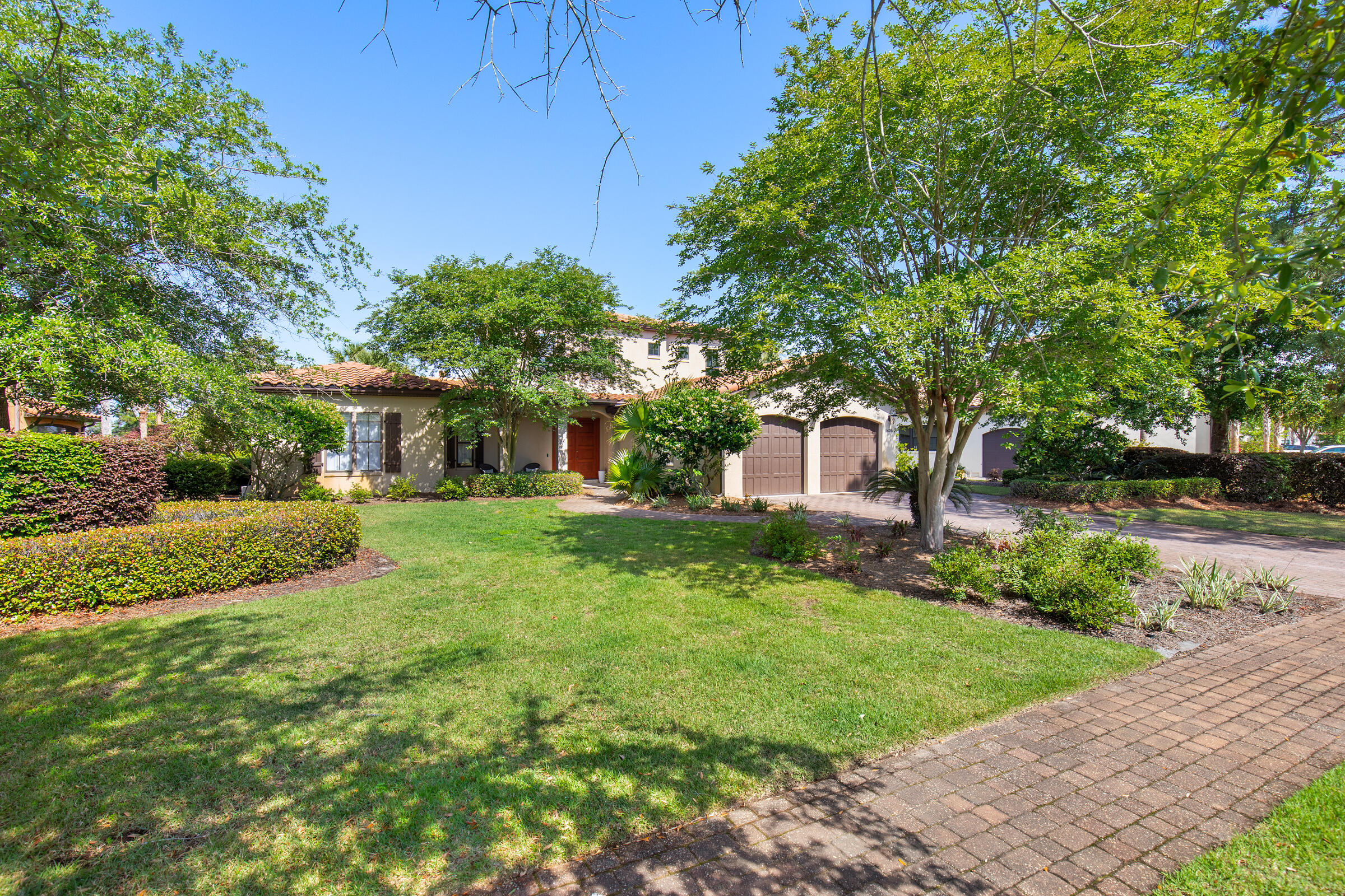 Tucked within the prestigious Genoa neighborhood at Sandestin Golf and Beach Resort, this Mediterranean-style home offers an inviting blend of warmth, elegance, and easy resort living. Set behind a charming stone bridge and centered around a sparkling lake with a fountain, Genoa is known for its stately homes and peaceful, private setting on the bayside of Sandestin.

This thoughtfully designed floor plan lives mostly on the first floor, centered around a bright, open living space where travertine floors, high coffered ceilings, and French doors create a relaxed yet refined atmosphere. The kitchen, outfitted with stainless steel appliances and abundant storage, flows seamlessly into the living and dining areas, all overlooking the pool, lake, and Baytowne Golf Course beyond. The screened-in outdoor area is a true retreat, with a sparkling pool, hot tub, covered patio, and cozy gas fireplace, perfect for year-round enjoyment. Fruit trees, potted plants, and lakeside views complete the lush Mediterranean feel.

The oversized primary suite features private pool access, dual closets, and a spacious bath with a soaking tub and separate shower. A second guest room and office are also conveniently located on the first level, with two additional bedrooms upstairs for family or guests.

A two-car garage plus golf cart bay provides plenty of room for storage and adventure, whether heading out to explore the resort's world-class amenities or the nearby Grand Boulevard Town Center. Owners at Sandestin enjoy access to four championship golf courses, tennis and pickleball courts, miles of biking and hiking trails, a 210-slip full-service marina, and the vibrant Baytowne Wharf for dining, shopping, and entertainment. Grand Boulevard, with its array of shops, upscale restaurants, movie theater, coffee shops, and Publix, is just a short golf cart ride away.