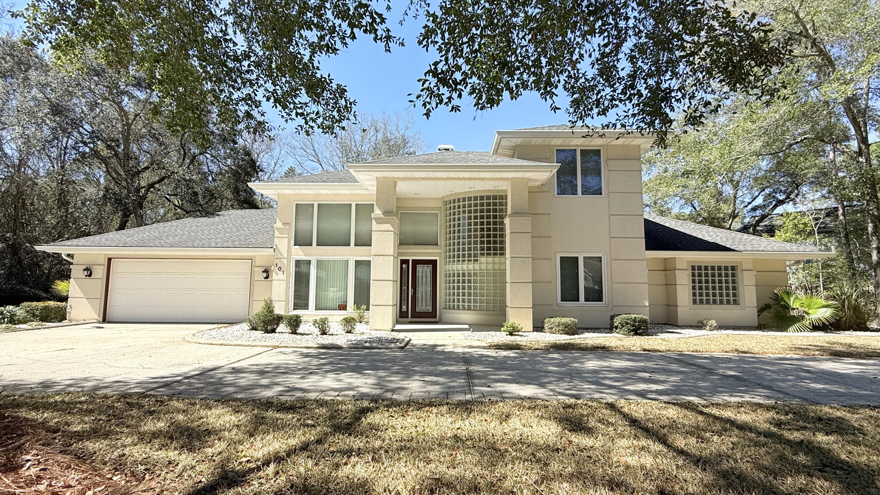 One-of-a-kind Luxurious, Custom-Built Home in Bluewater Bay!  Situated on a beautifully landscaped .49-acre corner lot with 20 feet of lake frontage, this distinctive property features sculptured architectural detailing and a dramatic curved glass block wall. The grand two-story foyer opens to spacious living areas including a Family Room, Formal Dining Room and a Large Living Room with gas fireplace! The remodeled kitchen (2023) offers quartz countertops, soft-close cabinets, walk-In pantry with wood shelves, updated stainless appliances, built-in wall oven, microwave, and a large island with cooktop and multiple pan drawers. The Breakfast Room has a trey ceiling & overlooks the lush backyard and lake. The main level includes a Guest Bedroom, Half Bath, and Laundry Room with sink. The Primary Suite features a tray ceiling and a spa-style bath with dual vanities, two closets, jetted garden tub framed by glass block windows and separate shower. Upstairs, there are two oversized bedrooms, each with a private full bath; one includes a walk-in closet and balcony with composite wood decking. Outdoor living is enhanced by an oversized screened porch, metal fencing, a large low-maintenance composite wood deck that maximizes enjoyment of the Florida weather! There is a lawn pump & full sprinkler system.  2-Car Garage is Oversized! Recent updates include 2017 roof, seamless gutters & new Kitchen windows; 2023 LVP Flooring; 2025 water heater; 2021 front windows, and more!  See attached list of improvements in the photos. Located in the highly desirable Bluewater Bay community near top-rated schools, restaurants, beaches and military bases.  Ownership entitles you to optional membership in Bluewater Bay amenities, including pools, a tennis center, a golf course, a marina, and waterfront!  Many recreation options just moments from your doorstep. Bike to the marina or take a short drive to Destin's shopping centers and some of the world's most beautiful beaches! This is a rare opportunity to own a distinctive property in Bluewater Bay!