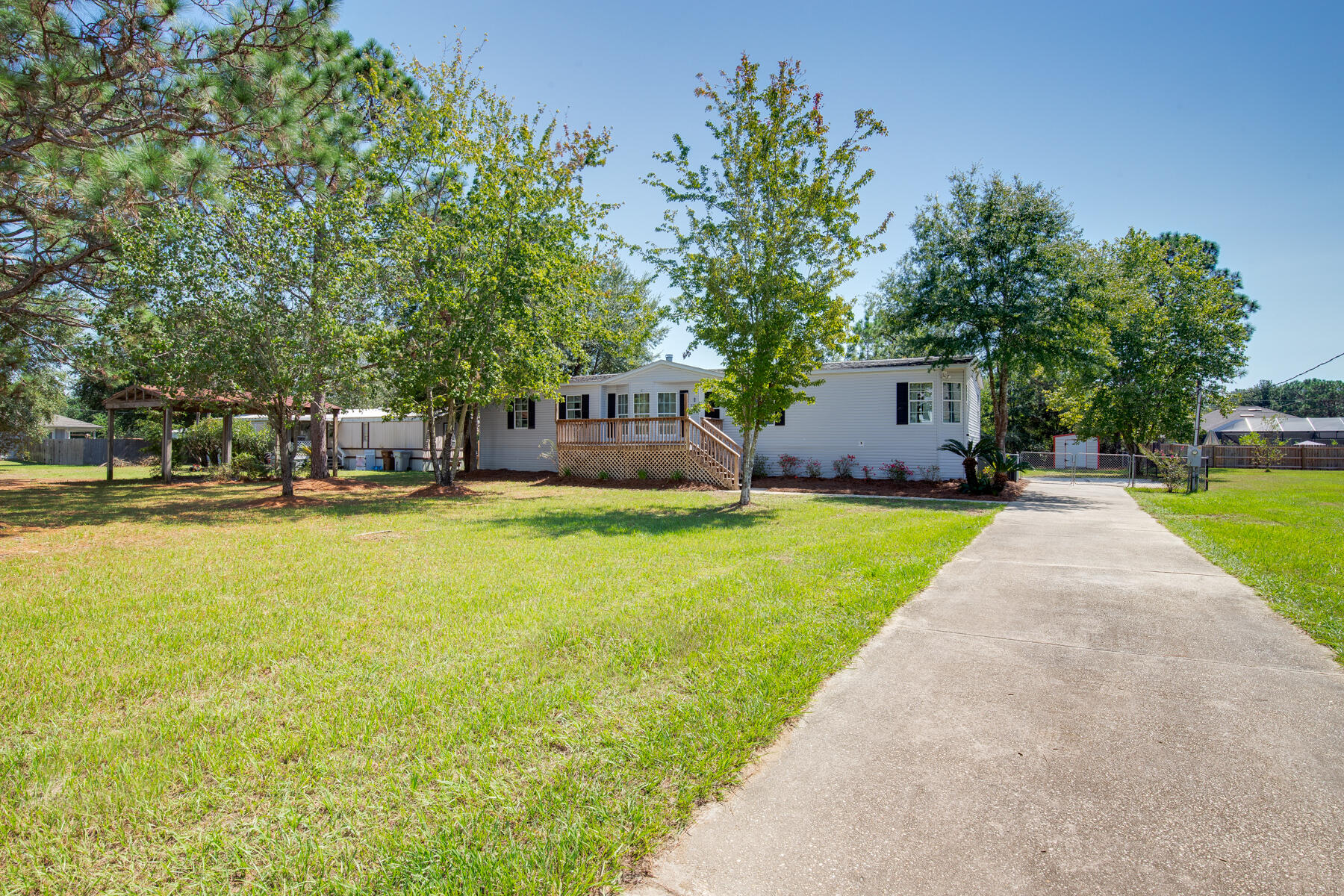 Welcome to this charming well-maintained three-bedroom, two-bath manufactured home. This property features a spacious and inviting floor plan that offers a family room and large open kitchen overlooking a cozy fireplace. Additional features include a laundry room, formal dining or office space, plus the convenience of a split bedroom layout with each bedroom offering a walk-in closet for ample storage. 

Outside, relax on the front porch or host gatherings on the expansive back deck overlooking the large fenced in back yard. Also located on the property is a power pole for RV hookup, a storage shed, and extra-long paved driveway providing additional versatility. Ideally located between the Beach and the Bay, this property is a fantastic option for a primary residence, a second home, or an investment property. Don't miss the opportunity to own this versatile and comfortable home on a large lot. Located in a prime location close to schools and just 10 minutes from the beautiful emerald beaches. Come enjoy all this home and beach town has to offer.