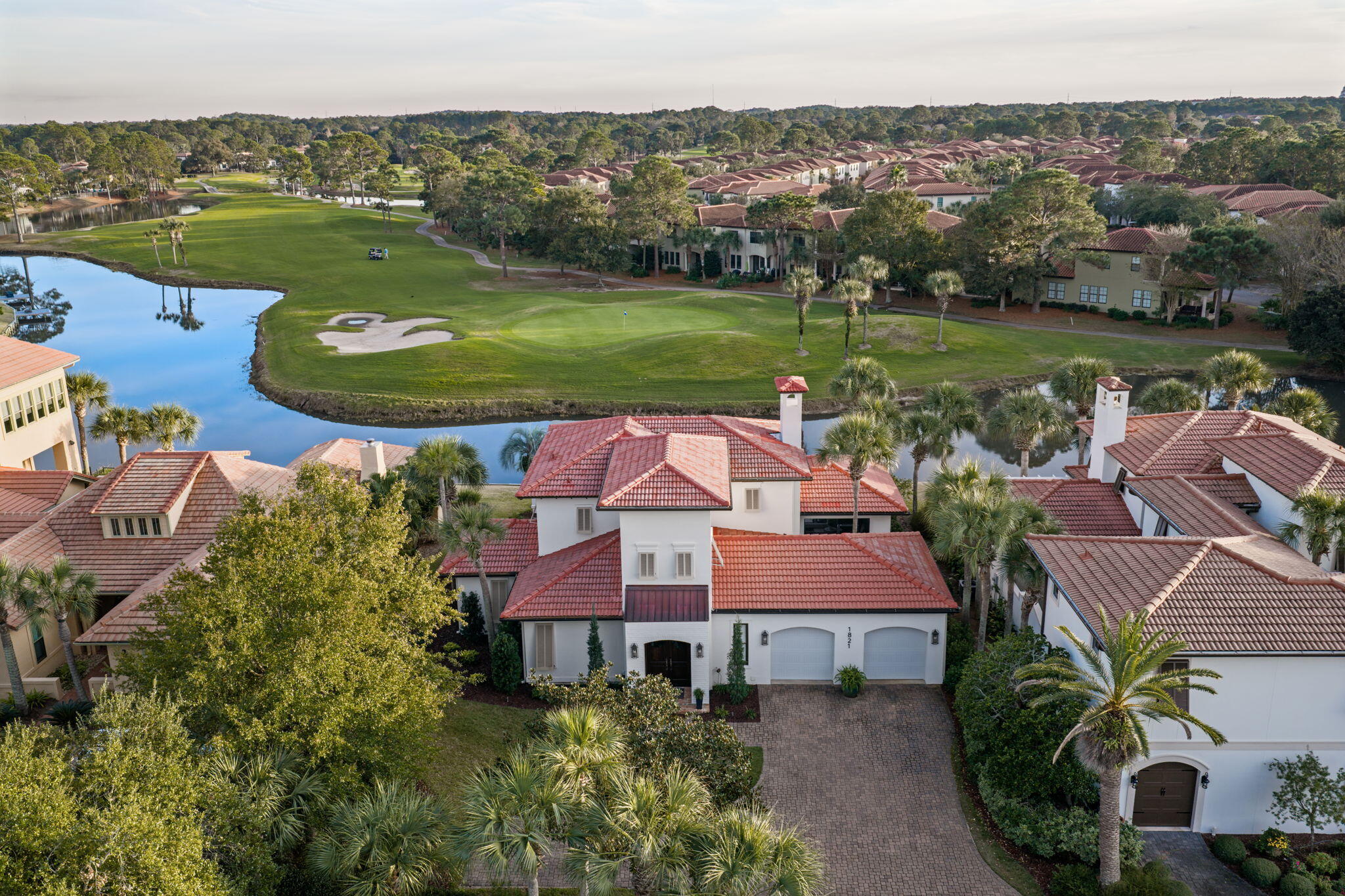 Experience refined coastal living in this Mediterranean Villa, perfectly positioned along waterfront landscape  and the beautifully manicured 4th green of the Baytowne Golf Course. Inside, you will find soaring 20-foot ceilings, bright open living space designed for relaxing and entertaining. Complimented by custom fireplace with built-ins create a warm yet elevated atmosphere. The newly remodeled kitchen features granite countertops, subway tile, Thermador professional gas range, Sub Zero glass front refrigerator, and hardwood floors that flow throughout the entire first floor of the home. Walls of windows capture sweeping water and golf views, filling the home with natural light. Step outside to your own private retreat with a screened-in porch, spacious pool deck, and a cozy fire pit area, perfect for slow evenings with friends. A new dock extends over the lakean unforgettable spot to watch sunrise shimmer across the water or take in golden sunsets over the green. What truly makes this home special is its location inside Sandestin Golf & Beach Resort. You're wrapped in 2,400 acres of 4-championship golf courses, a full serve marina, tennis center, miles of walking and biking trails, dining, shopping, and the freedom of golf-cart living.