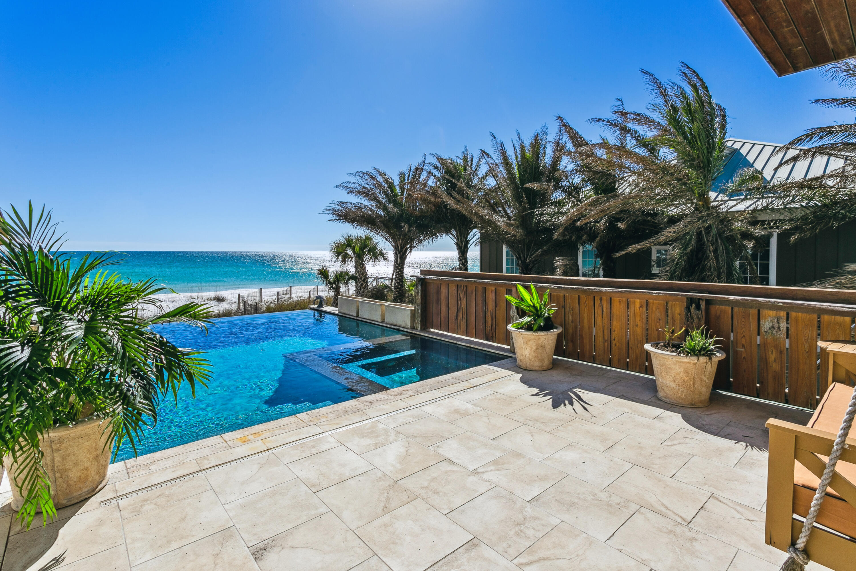 The First Gulf Front home offered on Pensacola Beach in over a year affords one the rare opportunity to own luxury property at one of the highest elevations on the beach. 
Completely renovated down to the heartwood studs over a span of 2 years and completed in 2020, this home has been rebuilt with the comforts of modern luxury but preserving the benefits of the coastal construction line (distance from the gulf) from the 1980's. 
 In addition to views of the gulf you will love relaxing in the heated infinity pool and hot tub. The modern open floor plan is perfect for generous living and entertaining. The chef's kitchen with the island topped in  a marble countertop that seats 6, beckons you to linger for another drink while watching the chef at work on the 48 inch gas cooktop. The honed Superlative marble countertop is functional and elegant- a centerpiece for the monochromatic neutral palette of white in the open concept living space. The main living area and primary bedroom are wrapped in shiplap wood planks for a coastal-cozy textured finish. The adjacent primary bedroom is positioned to overlook the gulf of Mexico and the infinity pool, with sliding glass doors leading to the wrap around porch. 
The Primary on-suite bath has a large travertine clad shower, double vanity and the walk-in closet maximizes space with drawers, and shelving for organization. You will love the huge 3 car garage with 10 foot tall doors and storage area for outdoor toys plus the first bay has an extra wide garage door for your oversized trucks or boats. The pool "tower room" is guest luxury with an ensuite bath and a juliet balcony overlooking both the infinity pool and the Gulf of Mexico- perfect views for the Blue Angels. This Pool house (a new addition in 2020) has a completely separate entrance from the pool so that you can use it as a rental or for complete guest privacy. It even has roughed in plumbing and electrical for a future kitchenette. The fenced in side yard is the perfect spot for pets or a sizable addition to your coastal dreamhouse.  The Pool house and Entire home have impressive rental projections.
