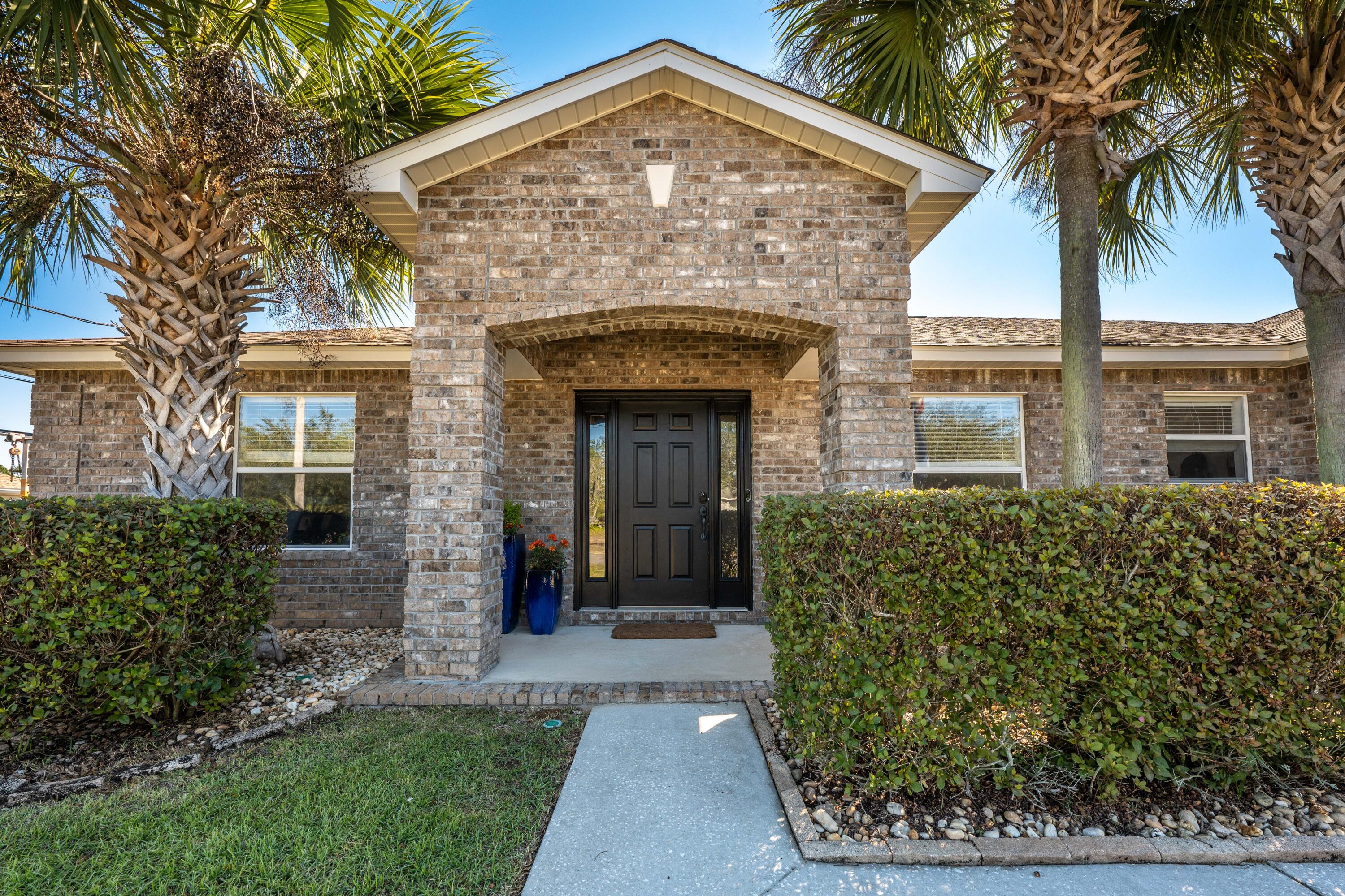 This turnkey, all brick home is just what you've been looking for! The open concept living is airy, spacious, and great for entertaining. The remodeled kitchen has a full granite slab island bringing you to the heart of the home. Luxury Vinyl Plank flooring throughout the home, LED Lighting, and Smart Home compatible can lights, are just a few of the many upgrades completed in 2019. The split bedroom floor plan allows for a large, private primary bedroom with ensuite bathroom offering separate shower & garden tub. The front bedroom has French doors so it can also be used as an office or gym. The oversized 2-car garage has upgraded overhead lighting, luxury garage screen, WiFi garage door, wired for 220V/50amp to be used for electric car or large power tools. Perfect for workshop or home gym. Don't forget your toys! The driveway extends beyond the fence for private storage of RV or Boat. While we are talking outside; this home sits on just shy of half an acre on a raised and graded lot to keep you high and dry during the rainy seasons. Out back there is a screened in patio overlooking a large, lushly planted, private backyard that is large enough for a future pool. This beautifully upgraded home is in a fantastic location! Easy commute to Hurlburt Field, near Navarre Beach, and other amenities. The best of Navarre with no HOA! Seller will replace roof with acceptable offer and don't forget to ask your agent to show you the Upgrades, Improvements & Features List!!