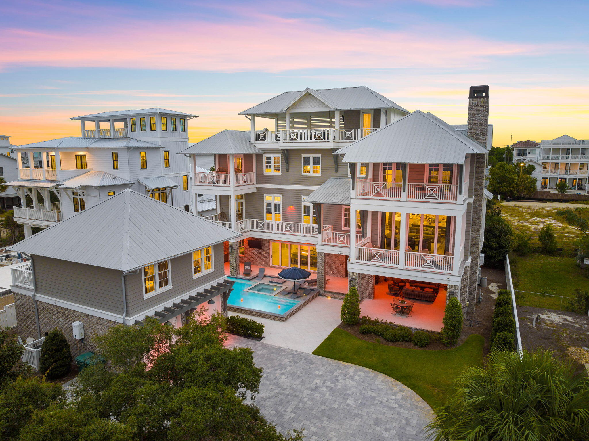 Established in 2020 to offer the true epitome of luxury coastal living, 296 Pompano Street encompasses 5,600 square feet of meticulously planned living space curated by Iva Design and executed by the talented building team at Becktel Construction. The prime homesite totaling a third of an acre is perfectly positioned to capture the covetable views of the white sugar sand and majestic turquoise hued waters while upholding a heightened sense of privacy with a fenced perimeter and gated entry. Upon initial approach, the stately front courtyard echoes the soothing sound of cascading water from the resort-sized pool while providing access to the two-car garage and grand entry foyer. Centered around the outdoor oasis, the first level includes an eat-in kitchen, living area, guest quarters, and seamless access to the outdoor living areas, grilling station, sunning deck, and private pool with integrated lounging ledge and spa.

Overflowing with grandeur, the main living area on the second level showcases the idyllic views and curated design experience featuring beamed ceilings and exotic mediums gleaned from a variety of different regions. The gourmet kitchen is a masterpiece with custom Fuller Brothers cabinetry, an oversized island with breakfast bar, butler's pantry, and professional appliance suite. Blurring the line between indoors and out, the bi-fold doors lead way to the covered porch spanning the full length of the second floor contributing to the nearly 3,400 square feet of outdoor living space incorporated into the custom floorplan. A secondary main suite, laundry area, and powder room complete the second level.

Interconnected by the full-service elevator, the main suite residing on the third floor embraces the captivating views and soaring beamed ceilings throughout the sleeping quarters, private porch, and sumptuous ensuite with dual vanities, tiled wet room, soaking tub, and oversized walk-in wardrobe. An additional bedroom suite, bunk suite, and office area are also found on the third level. Offering an additional layer of accommodation, the fully sufficient coach house nestled above the garage includes a full kitchen, bedroom suite, and living area.

Perched atop the roof line, the viewing tower is the perfect place to admire the renowned Emerald Coast sunsets which provide a new palate of mesmerizing hues each and every night. Bordered by thirteen acres of protected dunes, Inlet Beach continues to be one of the most sought after beach communities affording residents with a quaint coastal town flair while remaining geographically poised minutes from the town center of Rosemary Beach, Alys Beach, and all of the world class dining and entertainment venues 30A has to offer.

Effectively combining a rare culmination of unique and desirable amenities, 296 Pompano Street creates a compelling opportunity for investors and full-time residents alike. Inquire today to arrange a private viewing and start envisioning the coastal lifestyle you deserve.