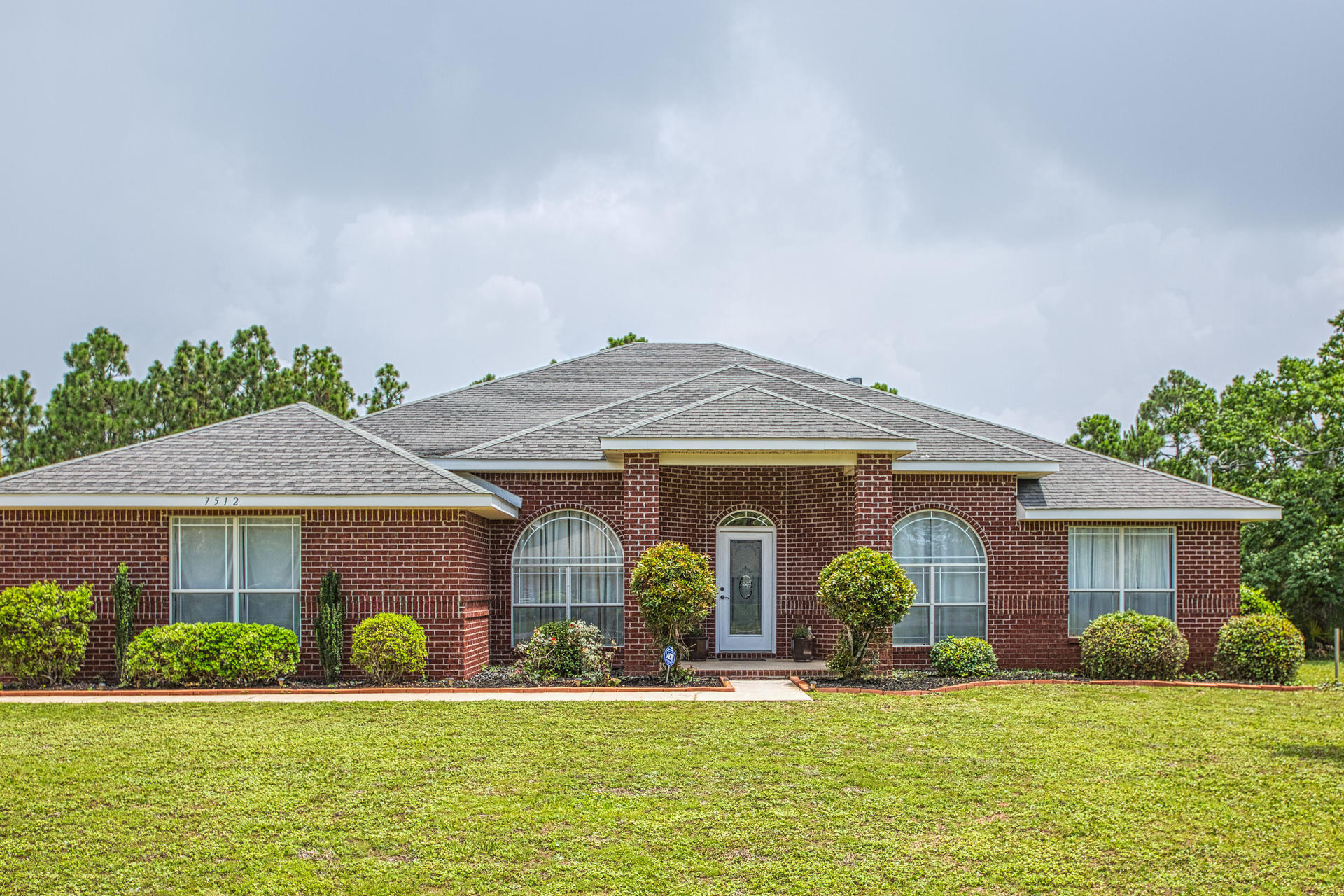 Tucked away in Holley By The Sea on quaint Frankfort St- you will find this expansive 4 bed, 3 bath, 3,000 sq ft. all brick home! This split floor plan is ideal for families- master on one side, kitchen/living room in the center, and additional bedrooms on the opposite side affording privacy for all. Sitting on almost half of an acre, the fenced outdoor space is great for children and pets, with space to add a pool if desired. Also in the back yard sits a custom shed large enough for all kinds of equipment and a concrete pad to store boats and jet ski's securely at your own home. A top of the line dual stage Trane AC help keep the electricity bills low even during the summer months. An oversized laundry room is complimented by a utility sink for convenience and tons of storage on shelves. Take advantage of all that Holley By The Sea has to offer and purchase this home for your family to enjoy for years to come!