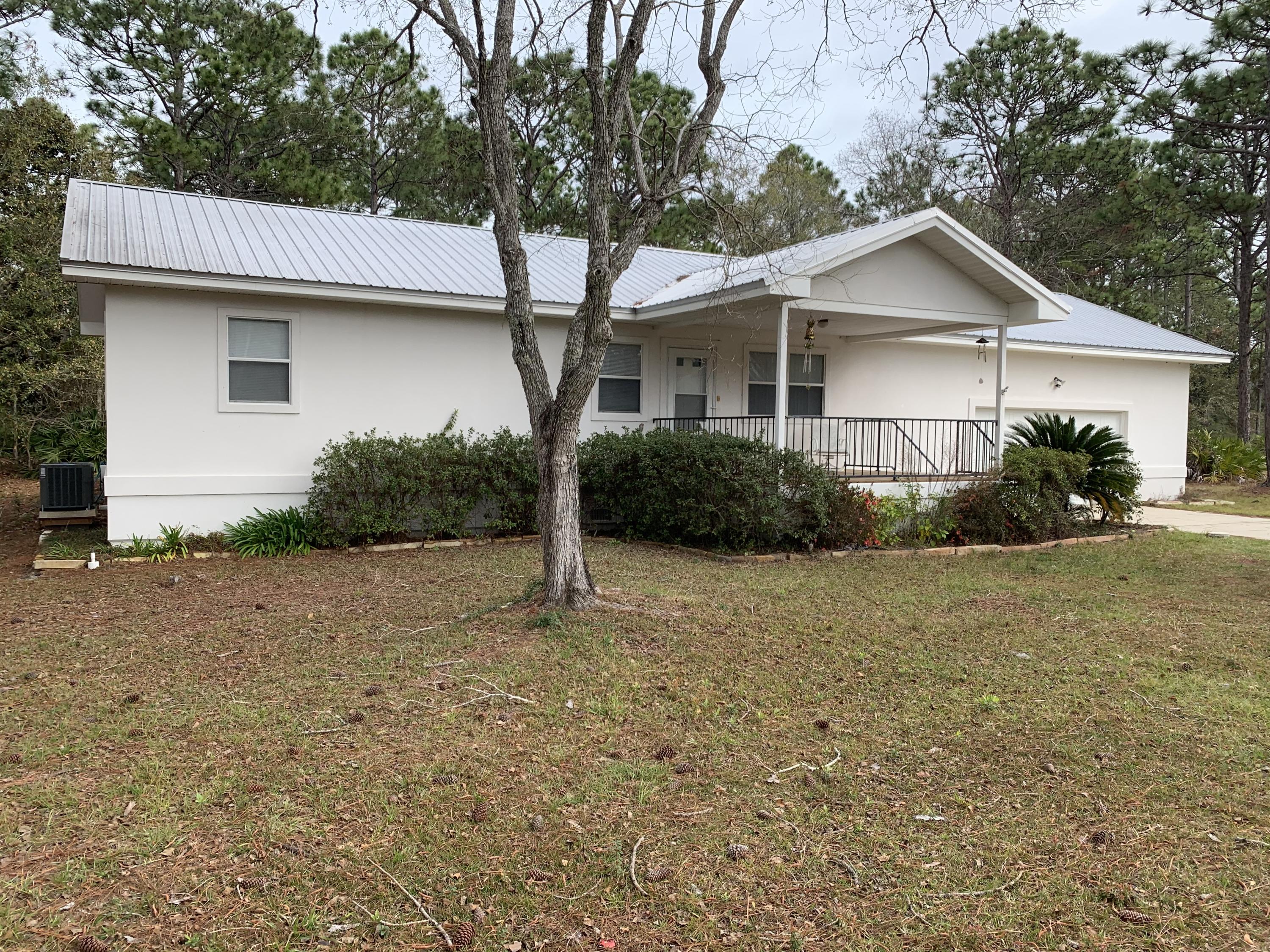 Adorable Florida cottage on .5+ acre lot, convenient to shopping, dining, beach and all amenities the area has to offer. The open floorplan is just right for modern living and opens to the large rear deck. The kitchen features all appliances, plenty of cabinet space and a picture window with views of the beautifully wooded back yard. The master bathroom suite offers a dressing area and a private shower area. The guest bedroom has plenty of natural light and access to the additional full bathroom from the hallway. Luxury vinyl flooring and tile flow throughout. Septic and well water means no water bill! Fresh paint throughout! The two car garage, with high ceilings is ideal for storage space. Both the front and back patio decks are equally spacious.