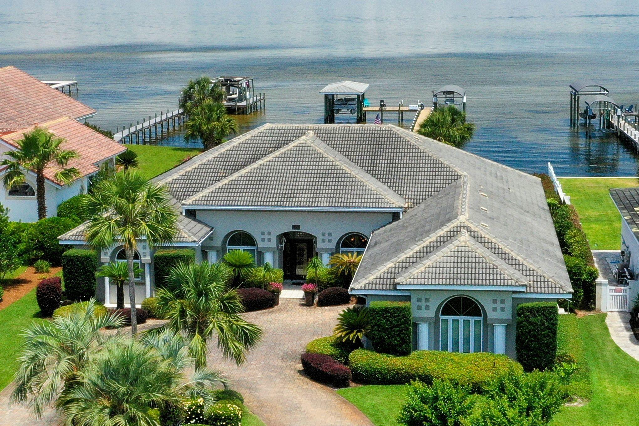 Wake up to beautiful mornings with endless sunrises and sunsets over looking the water from this beautiful waterfront home! Enjoy your coffee sitting around the sparkling pool listening to your favorite tunes on the surround sound.  There is nothing missing with this waterfront beauty in a wonderful gated golf course community! Sub-Zero Stainless Steel Refrigerator with a Dacor GAS Cook Top and Electric oven. The breakfast area over looks the pool and bay. The open family room has a great fireplace! A Salt Water Pool newly resurfaced and solar heated with a screened Lanai. Two new nice boat houses with lifts. The newly built dock is well lite with a large sunning area. Sprinkler system on well water. Seller taking back up offers on a contingency. Instant endless hot water system. Rip Rap Seawall! A/C & Heat were replaced 5 yrs. Oversized Garage & Storage 984sq.ft.  NO Flood insurance required! Seller would consider selling furnished for an additional price. Also, available one boat the 22 ft. center console with a Yamaha out board motor. 

The Community's roads are being upgraded now. The Emerald Bay Golf Course along with the Club House has recently been upgraded. The club house features convenient daily lunches. Owners receive a discount for Golf! Tennis and much more!