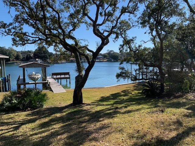 72 hour kick out clause in effect. Amazing opportunity to own waterfront property on coveted Cinco Bayou.  This large property sits high and dry and has a dock with boat lift with deep water access.  Open concept floorplan features tile flooring, vaulted beamed ceiling and a split bedroom layout.  Kitchen has stainless steel appliances.  Huge utility/laundry room. Two car garage with paver driveway has an attached area for your golf cart or motorcycle. Spectacular grounds with mature landscaping has room to build a MIL suite if needed. Enjoy your morning coffee watching the dolphins, pelicans, eagles, ospreys, otters, etc  on decks overlooking the bayou.  Experience the waterfront life!
