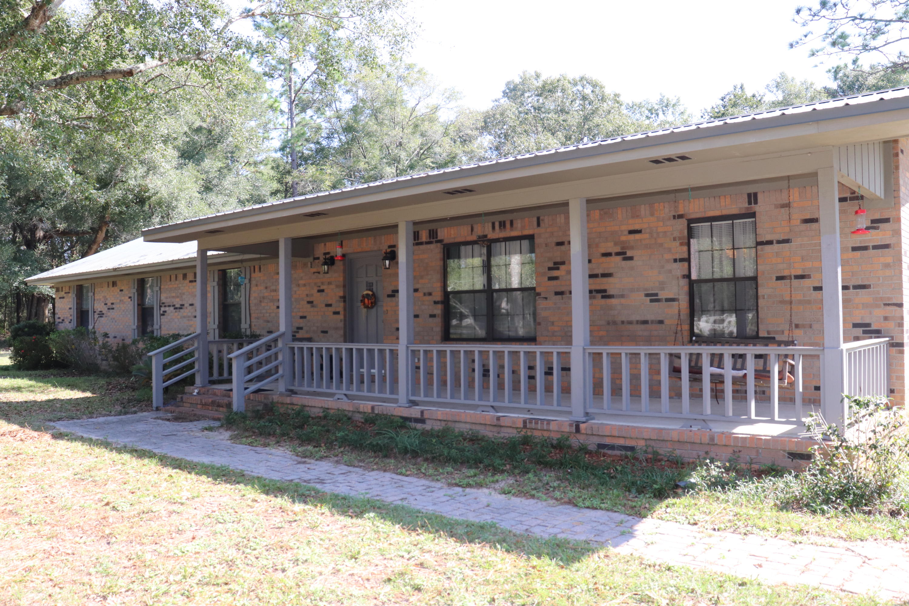 Bring the horses home to a custom well built home with 8.12 acres close to I-10.   All of the expensive things are already done for you on this immaculate and well cared for brick home with a metal roof (2013).  Brand new HVAC, tile in wet areas, large eat in kitchen with solid wood cabinets and a island with electric. The large living room features a wood burning fireplace, vaulted ceiling, and wood beam. Behind the kitchen  is a formal dining room and formal living room. The seller has thought of everything when they added larger and extra closets throughout the home. The laundry room has  extra space for storage, a laundry sink' and bathroom. Beautiful sunroom and large front porch. Outside on the property are large beautiful trees, a treehouse for the kids, a  separate workshop with a metal roof and underground utilities, 3 horse stalls and a feed room also with underground utilities. Buyer to verify square footage.