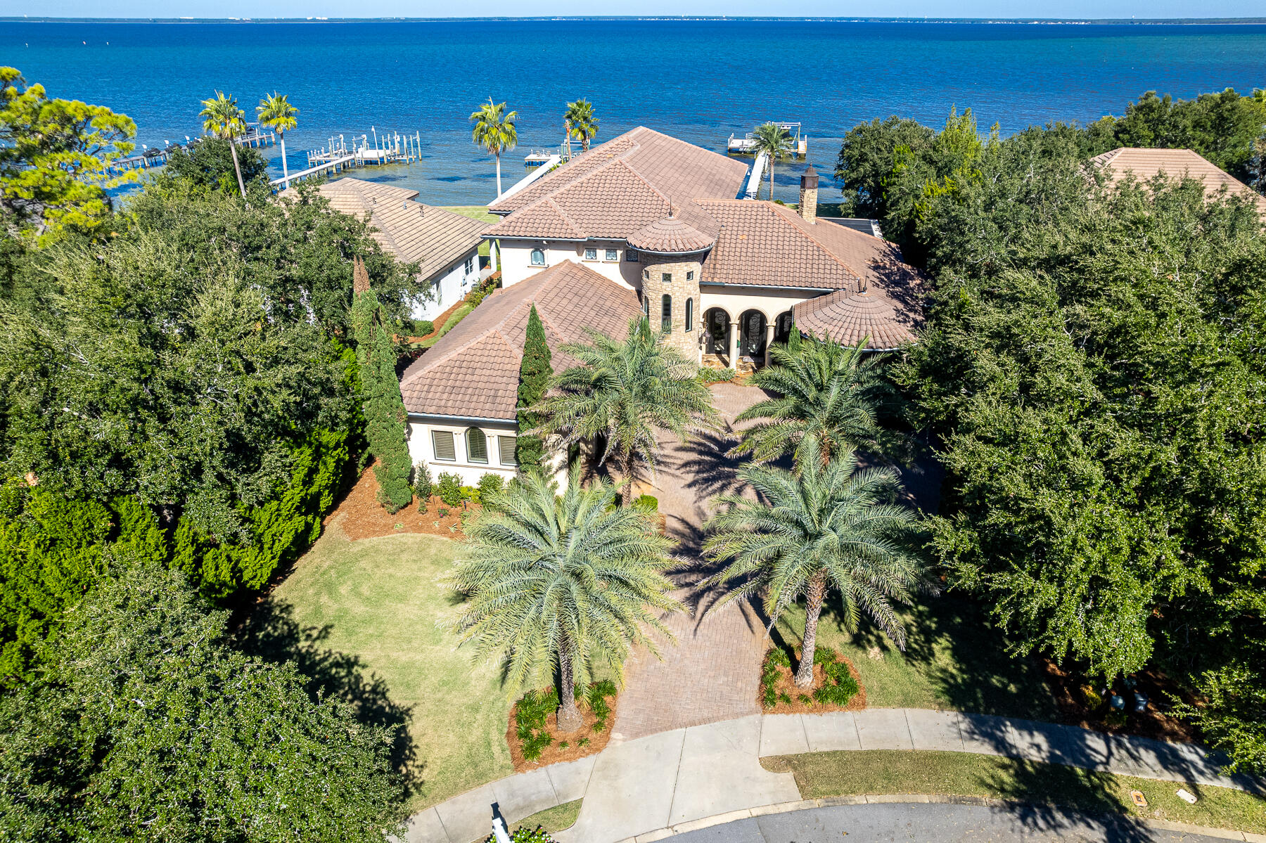 A rare and exclusive waterfront home in the private, gated enclave of Kelly Plantation located in Destin, Florida. 4500 Bellbouy Landing is a trophy estate, constructed, finished, and fixtured throughout to a meticulous standard. Its impressive lot, fronting the scenic Choctawhatchee Bay, expands 103' along the tranquil waterfront setting, while the enormous, estate-sized lot contains lush, mature landscaping and fabulously maintained grounds. The 6-bedroom, 6-bath home measures approximately 6,506 square feet of conditioned space, while the total improved square footage is approximately 8,402 square feet. Custom-designed and constructed in 2010 by the legendary homebuilder, Don Keener, this Tuscan-style masterpiece was the awarded spotlight of the 2010 Parade of Homes. The... , classic interior was accentuated by the award-winning designer, Duce May of Duce & Company. The expansive master suite is located on the first floor, as well as a guest suite. The master suite features (3) custom walk-in closets along with a large luxurious bathroom with his and her vanities, a spa-like soaking tub and dual showers. This master retreat presents luxurious finishings and Fine Art lighting fixtures that are showcased throughout this entire magnificent estate. The millwork and stone throughout exhibit fabulous detail, which includes knotty Alder doors and various rare and polished stone countertops and floors, together with beautiful hardwood floors. The kitchen is extraordinary, including the outdoor summer kitchen with the full array of the most desired appliances including a Miele built-in coffee/cappuccino maker, (6)-burner Thermador gas range with double ovens, Sub-zero refrigerator, (3) dishwashers, and gas grill! The spacious Transtherm wine cellar stores up to 209 bottles. The second floor contains four large guest bedroom suites. The phenomenally large multi-use room, yielding a vista across the bay that is breathtaking, features a wet bar, refrigerator, and ice maker! The screened lanai and heated saltwater pool offer a wonderful outdoor experience, while the oversized dock with ThruFlow decking, new 32' boat slip with 10,000 lb. boat lift, and (3) new jet ski lifts provide a sensational coastal lifestyle.
The whole-house generator is a wonderful asset to provide further peace of mind, coupled with the structural integrity of this stunning home. The smart home features are operated via Savant Home Automation System technology. The oversized 3-car garage is one of the largest in all of Kelly Plantation, a private, rental-restricted and planned community with vast amenities including but are not limited to, golf (separate membership required or pay per play green fee), tennis, pickleball, pool, yoga/fitness studio, clubhouse, volleyball, and many miles of walking trails. Unaffiliated, albeit accessible amenities in proximity are equestrian stables and a marina, which also offers the practicality of a boating club.
Enjoy the waterfront lifestyle on the Emerald Coast in Kelly Plantation of Destin, Florida! The incredible white sand beaches, restaurants, shopping, venues, and Destin Airport are only a short car ride away! All showings must be accommodated by the listing agent(s) and require a scheduled appointment with (48)-hours minimum notice.