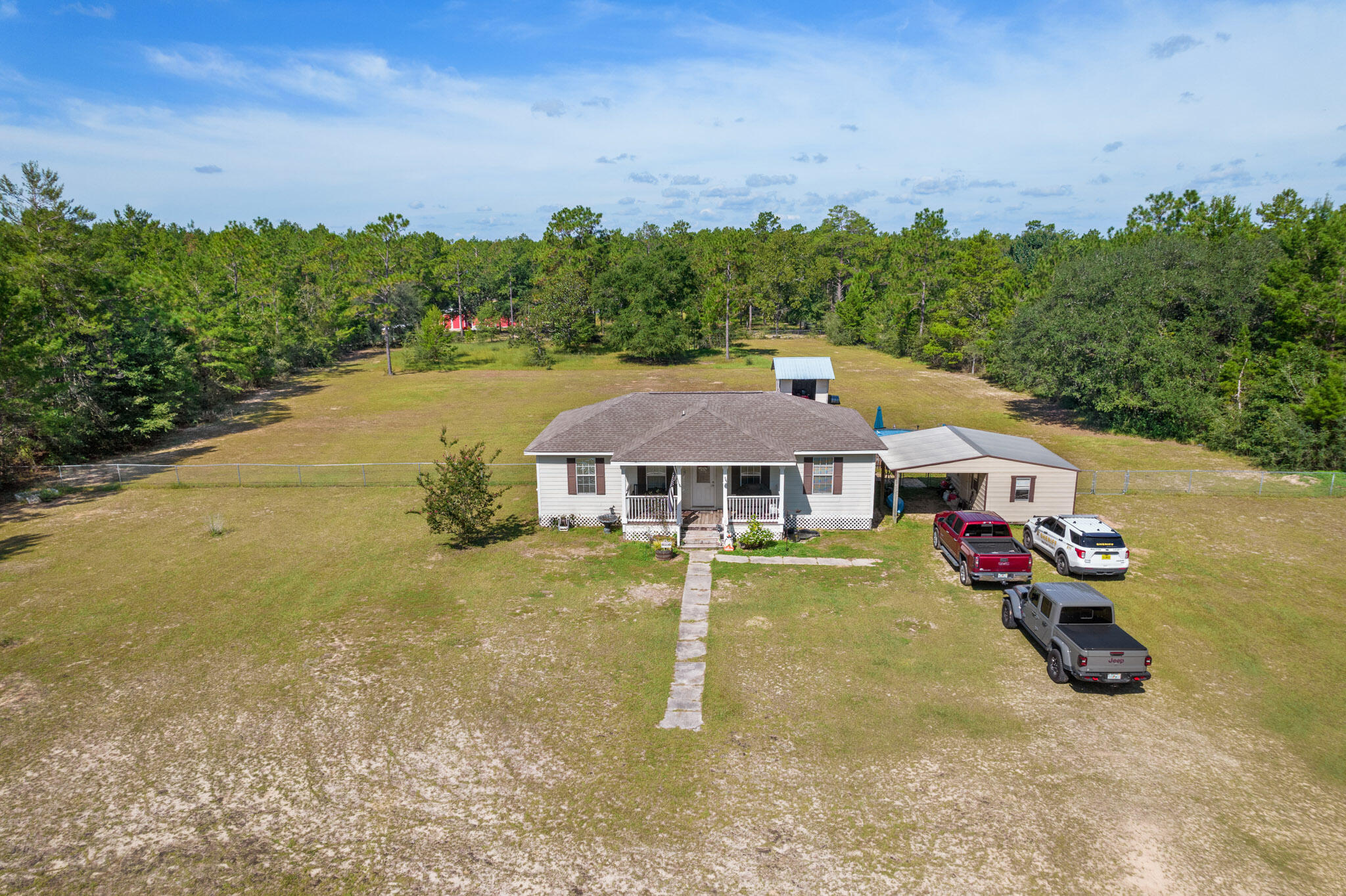Adorable & renovated 3 bedroom 2 bath home in a quiet country setting . Covered front porch invites you to sit and visit for awhile and enjoy the quiet and cool breezes. Cleared & fenced 2 acres! Horses allowed and owners have use of 4 lakes in the area! So many updates: completely remodeled the inside. The kitchen remodel (8k) included adding more cabinets- Reflection by diamond Maple cabinets with Hanson style doors, thatch finish and cup hinges. The counter tops were replaced and features a breakfast bar top as well. The appliances in the kitchen are whirlpool, and the dish washer was replaced this year.
New flooring (3k) in the kitchen and throughout the house. The bathrooms were updated with new toilets, light fixtures, and vanities. Seller replaced all the base boards in the house and built casings around the windows and door frames! New HVAC approximately 2 years ago (5k). New roof in 2019! The building was put on the property in 2018, includes storage/garage area and carport area. (6k) and recently had power ran to extra building. Deck & above ground pool (5k). Ready for your new home and 2 acres? Call today!
