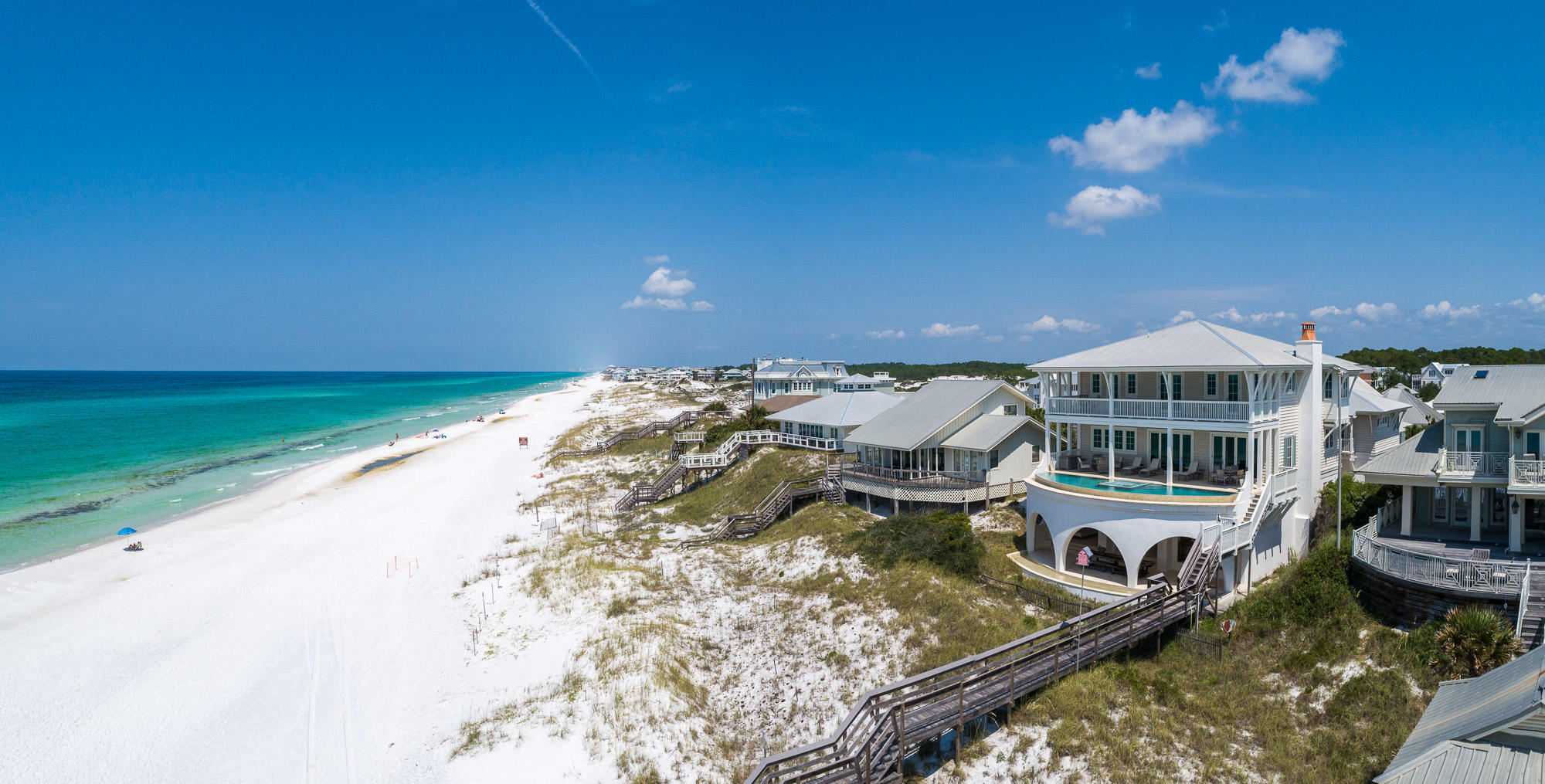 COMPELLING PRICE! This exquisite luxury Gulf-front residence, spanning an exceptional 70 feet on the Gulf, is aptly named ''Graytful'' and the name says it all! Grayton Beach is a community of neighbors that the New York Times has called: ''A Gulf retreat for the upscale but unfussy!'' The beach residence exudes a classic coastal style and was inspired and designed by renowned architect Chris Stoyles of Archiscapes and built by reputable Allen Wright of Velvet Sun Builders. The interiors are matched to perfection by Darla Wright of Darla Wright Interiors. This 6 bedroom, 6 -1/2 bath Gulf-front retreat boasts over 6,000 sq ft of heated and cooled living space and will be your estate forever. Look out every day from your kitchen, dining and living room windows to the emerald green waters of the Gulf of Mexico. This site is special indeed and boasts a large footprint and is one of only seven gulf front lots that own all the way down to the mean high tide line. Grayton Beach State Park borders the east and west sides of this small Gulf-front community that is as eclectic as it is bohemian.
An exceptional first impression greets you as you drive through the gated, arched entry with a stunning immediate view corridor directly under the home to the Gulf of Mexico.  The arches that open up to the Gulf are supports for the second floor curvilinear, negative edge pool that spans the width of the house, complete with waterfall and catch basin. Entering the glass doors the first level flooring is stained concrete that wears well when coming back from the beach to the indoor shower and changing room/locker room.  If you want to relax in the shade, there is a queen size swing bed hanging in the covered area as well as a 16 foot long custom-made dining table for outdoor dining and party events.  The first floor "man cave" is complete with pool table and bar area with big screen TV and dual hurricane-rated garage doors opening up to the Gulf-front letting airflow completely through the first level. Ascend the stairs, or take the elevator, and receive a jaw-dropping welcome of unobstructed Gulf views. The large chef's kitchen with Wolf stovetop and subzero appliances lends an ideal design for entertaining and a huge Butler pantry provides a tidy home for the large storage shelving and separate ice maker.  The large marble counter is home to many evening meals and fun parties.  Everyone gets to enjoy a view, whether you dine at the dining room table or walk outside and have drinks and dinner overlooking the negative edge semi-circular pool with hot tub.
The living room is poised Gulf front and just off the dining area, complete with large screened TV and ample seating for everyone.  The owners will leave their large Fiddle Leaf Fig Tree or remove it if you wish.  The north wall is completely covered in book shelving and ready for your library(none of the books convey).  One guest bedroom and bathroom as well as the guest powder bath are on this level   Exiting the rear of the home through the breezeway, you are connected to the oversized carriage house.  Complete with full kitchen, dining, den and sitting room, this carriage house could be a turn-key separate and private 2 bedroom, 2 bath home for parents or married  kids with their children.
Mounting the stairs onto the third level, the Gulf front porch extends the length of the house with commanding "see forever" views.   There are three bedrooms on this floor, each with ensuite baths.  The master suite/bathroom is 18x36 with separate tub for soaking and a shower with port hole so you can shower and look out at the Gulf.  The closet has "his" and "hers" sides with a convenient laundry shoot into the laundry room next door.  Two additional guest rooms are positioned on the west side of the house, large enough for private offices or bedrooms for a large family.
There are three garages with a gated entry way and ample storage.  A Hobie Cat 18' fits in one of the garages and could convey with the house if the buyer should desire. This immaculate residence is sold fully furnished with a list of exclusions.  All artwork on the vertical walls is excluded.  A list of other exclusions will be provided.
All room sizes and dimensions are estimates and buyer should verify that which they deem important.