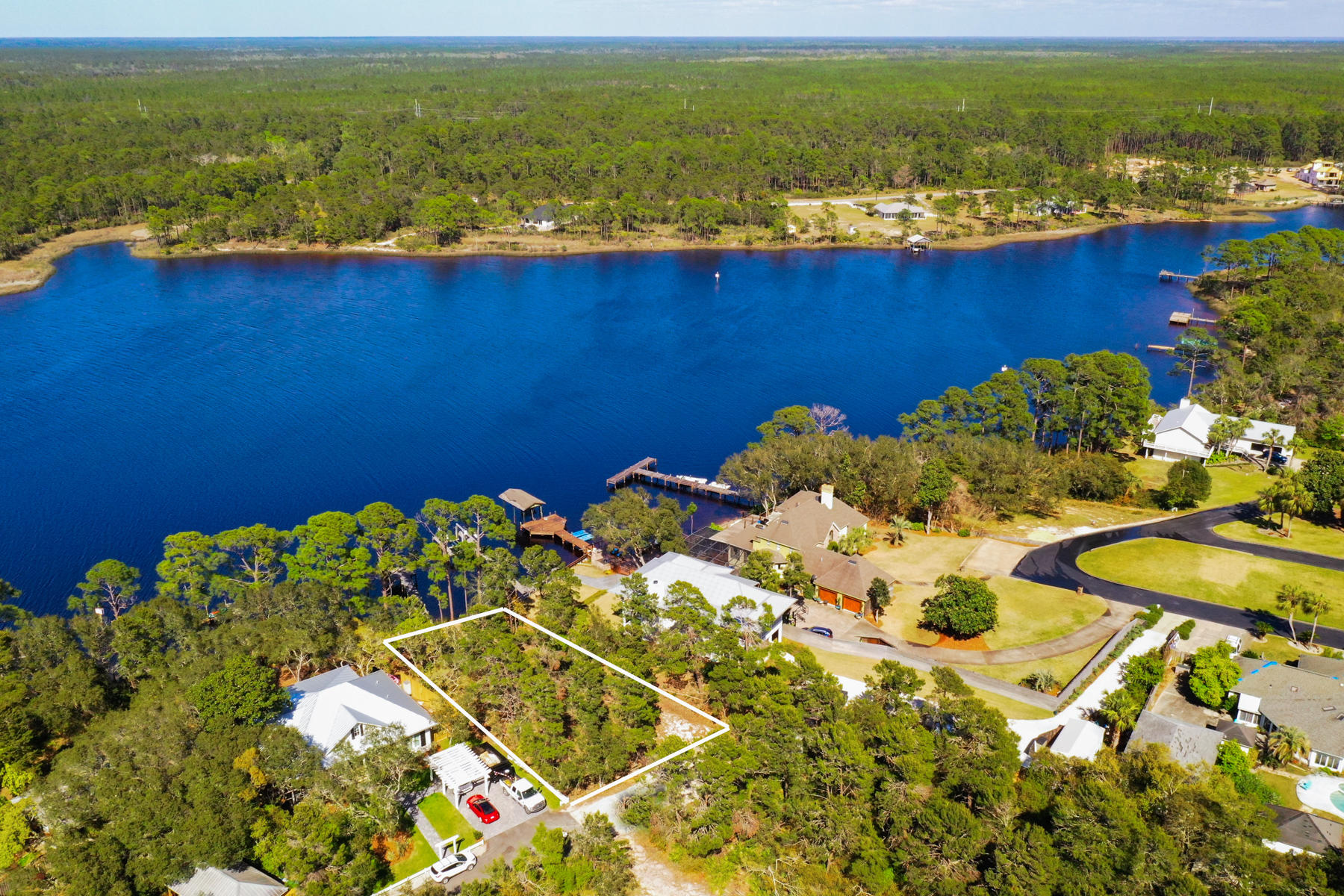 Occupying one of the highest elevations on Lake Powell, this wooded lakefront home site measuring 87 feet wide and 180 feet deep offers 0.36 acres on which to build. There's no HOA, and a seawall and dock are already in place. It's just waiting for a new owner to add their own special home for enjoying the peaceful lakefront lifestyle. Imagine swimming right off your own dock, or fishing in the brackish water which supports both freshwater and saltwater fish. Lake Powell is a rare coastal dune lake, found only in a few places in the world. It is the largest on the Florida Panhandle and holds the coveted designation of being a ''Pristine Florida Waterway.'' The calm lake waters are ideal for kayaking, canoeing and stand-up paddle boarding. Just five minutes along Highway 98, Camp Helen State Park has excellent hiking trails through the maritime hammock and salt marshes. Birders will spot many rare birds, particularly during the migratory season. The area is also home to white tail deer, squirrels and other wildlife. The white sandy beach and beautiful warm gulf waters at Sunnyside are just a mile away â€“ perfect for a morning jog or a stunning sunset stroll along the water's edge. The masterplanned community at Rosemary Beach is a less than 10 minutes by car. It attracts many visitors with its boutique shopping, al fresco dining and live entertainment. Twenty minutes away, Panama City Beach has excellent shopping malls, attractions and amenities including an international airport.