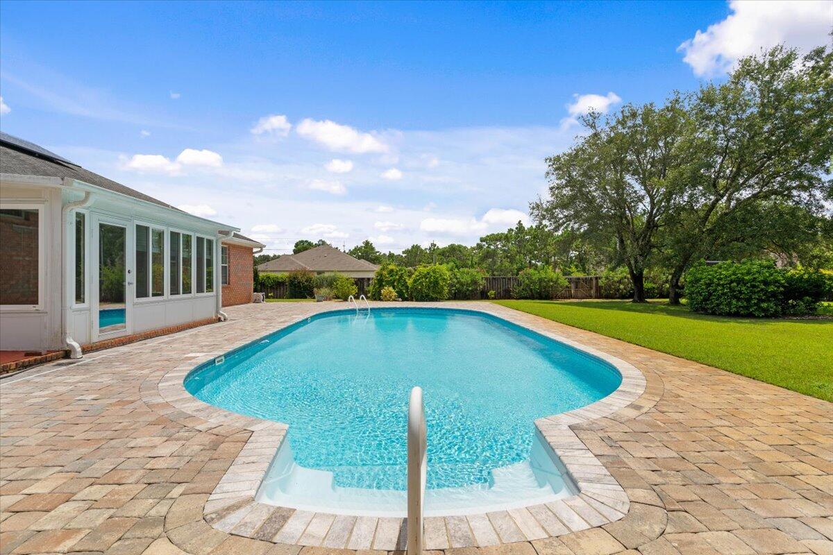 This move-in ready home offers 2,384 square feet of beautifully maintained living space on a sprawling half-acre corner lot in Holley By The Sea! Not only does this home have 4 bedrooms and 3 bathrooms it also has a fully enclosed heated/cooled Florida room that opens up from the main living area. From the Florida room you step outside and it opens up to the inground pool with a beautifully landscaped yard. This exceptional property sits on a prime corner lot with enhanced privacy and space, featuring seamless indoor/outdoor living that flows from the main living area through the year-round climate-controlled Florida room directly to the resort-style inground swimming pool surrounded by mature, beautiful landscaping. The home is completely move-in ready with fresh paint throughout and comes with incredible value-added features including a solar panel system. This property represents an exceptional value with immediate cost savings from significantly reduced electricity bills. Water heater is from 2024 as well as a newer HVAC system! Don't miss this opportunity to own a piece of paradise! Schedule a showing today!