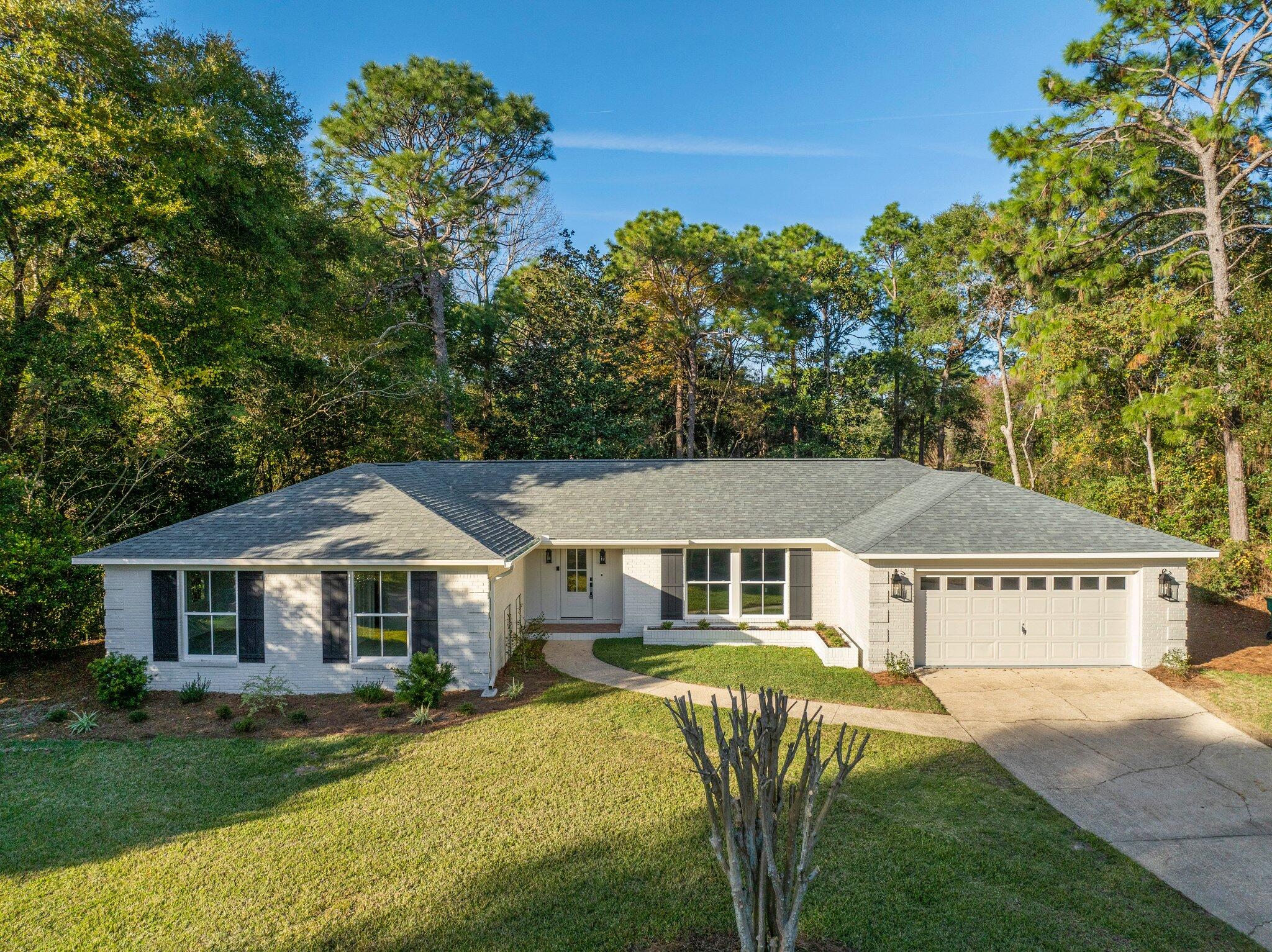 This beautifully renovated property is nestled in highly desired Rocky Bayou Country Club Estates. The single story home offers professional design with luxury amenities and stylish selections.  As you enter through the spacious foyer, the gorgeous 6.5'' wide-planked French oak hardwood floors immediately catch your eye.  Your attention is then drawn towards the custom private office/study with generous moulding details, a hidden wall closet, ample natural light and a rich slate color to set a sophisticated tone.  Leading out from the study connects you to the kitchen. Configured with entertaining in mind, the gourmet kitchen includes custom cabinetry, farm sink, an expansive island with integrated seating and a luxury appliance suite with stainless steel Forno refrigeration, french door electric range, dishwasher and microwave drawer. Custom shelving is flanked by additional cabinetry surrounding the coffee bar. 
The heart of this home is the expansive living area that sets the stage for unforgettable gatherings. The open-concept design effortlessly connects the living, dining, and kitchen areas, creating a space that is both elegant and inviting. The space is highlighted by the stunning unobstructed golf course views which can be seen from any of the 7 floor to ceiling windows along the rear of the home. To the far right of the space, you'll find an impressively sized laundry facility with abundant storage and cabinetry which also exhibits a large utility sink and landing zone upon entry from the garage. 
The large French doors welcome you from the great room into an outdoor oasis. Lush landscaping surrounds a beautiful patio offering a generous space to lounge and relax, looking through the plentiful mature trees onto the 9th tee box of Rocky Bayou Country Club.
Back in the interior of the home, the primary suite is located off the foyer and features his and her walk-in closets with custom cabinetry and an elegant en-suite bathroom. A large free-standing soaker tub and walk-in glass shower are the highlights of this space.
Down the hall, three additional generously sized bedrooms ensure comfort and privacy for your family or guests in addition to a well-appointed guest bathroom with a large dual vanity and walk-in glass shower. The guest bath details a separate entrance into one of the bedrooms for privacy and convenience. 
Rocky Bayou Country Club Estates is a wonderful community. Don't miss the chance to make this exquisite property your own. Contact us today to schedule a private viewing.